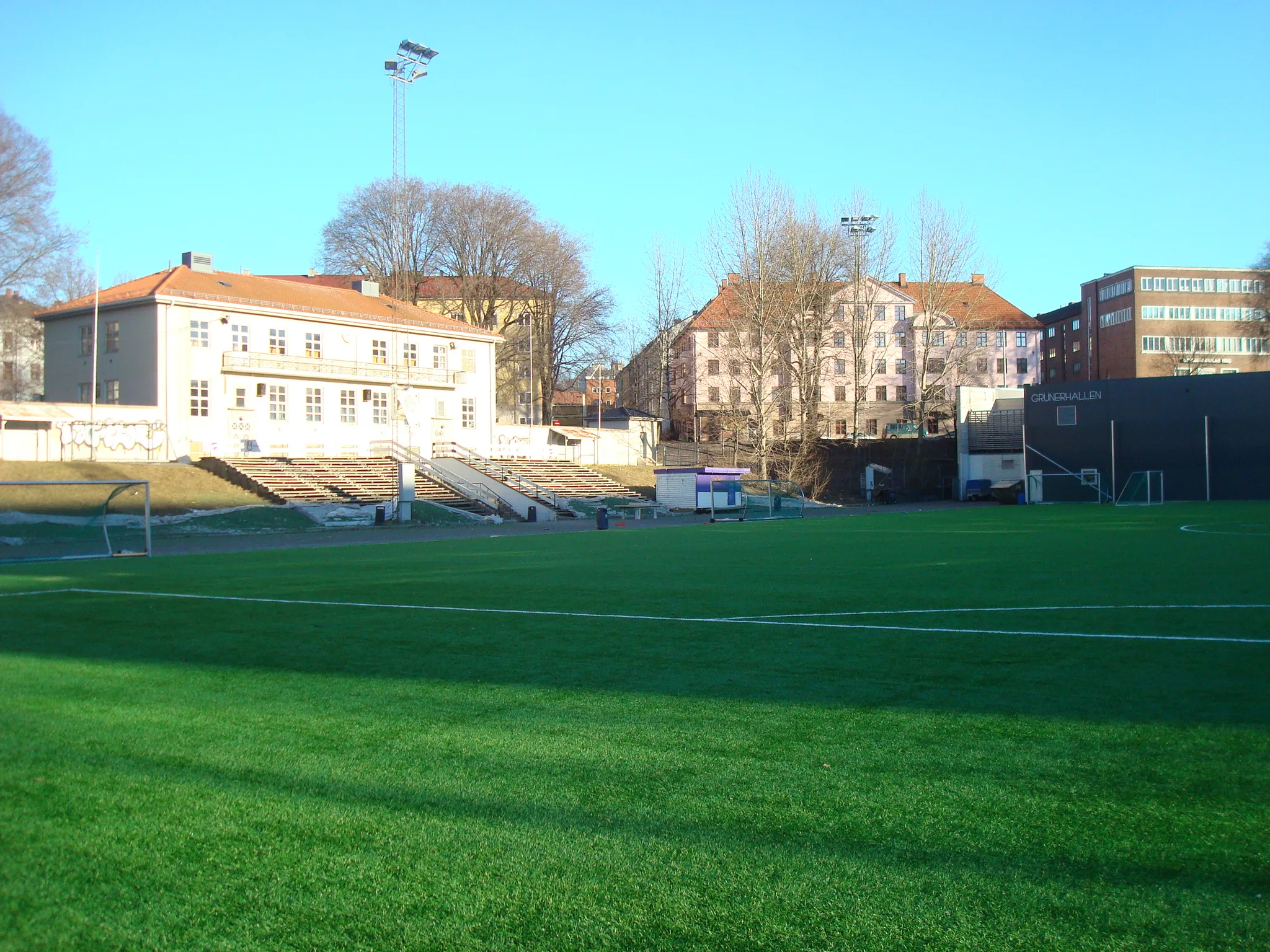 Photo showing: Dælenenga idrettspark i Oslo, 2015. Gressbanen, klubbhus og Grünerhallen.