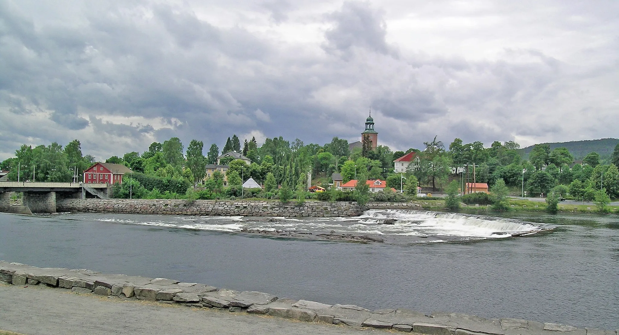 Photo showing: Kongsberg. Numedalslågen, Nybrufossen and Vestsida. Nybrua to the left. Kongsberg church and Bergskrivergården.