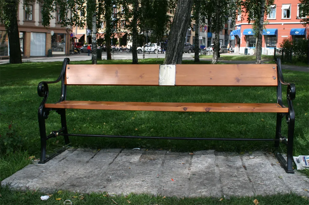 Photo showing: A parkbench set up in memory of Norwegian musician Robert Burås (1975–2007) in the Birkelunden park in Oslo. Burås was a frequent user of the park.