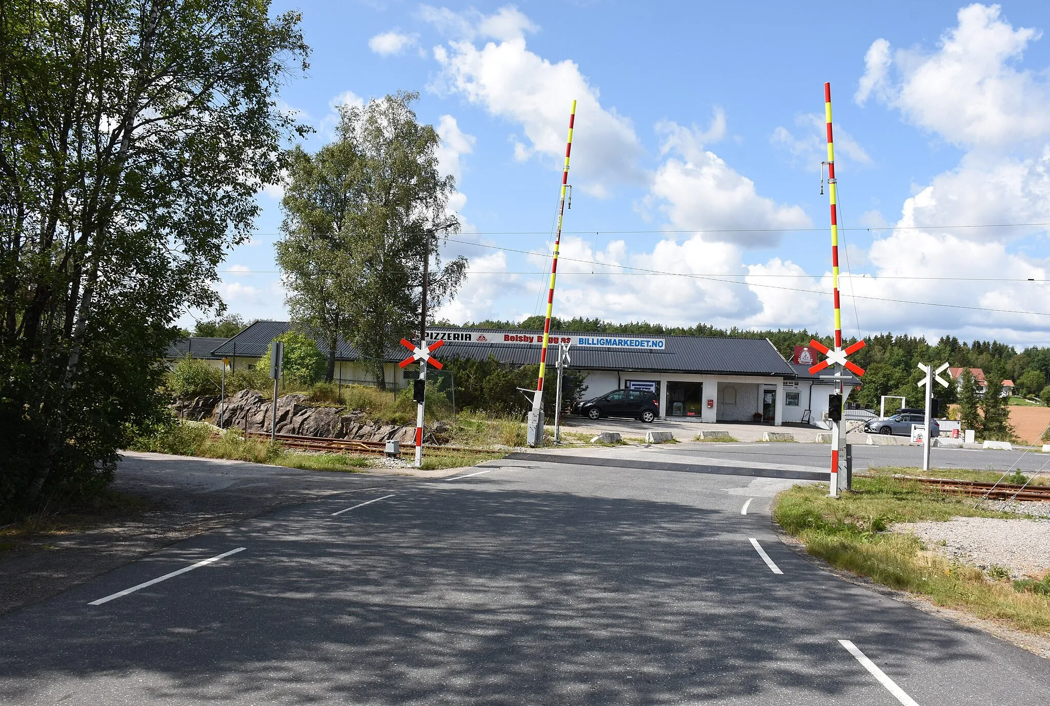 Photo showing: Fylkesvei 1206 krysser Østfoldbanen på planovergang sør for Ise stasjon.