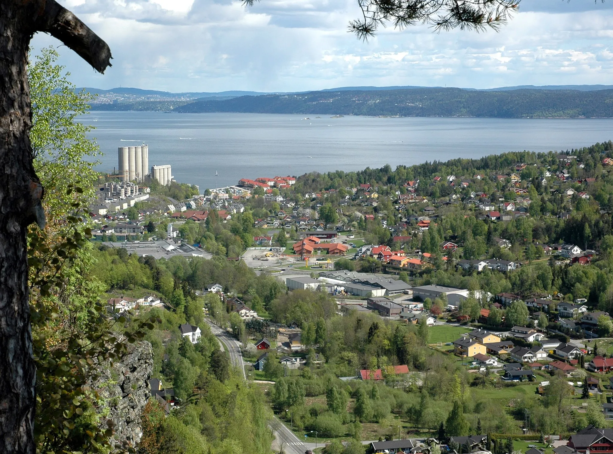 Photo showing: The hamlet of Slemmestad, Norway, seen from the hill Bøsnipa. Picture taken looking east, with Oslo seen in the distance, across the Oslo fjord.
