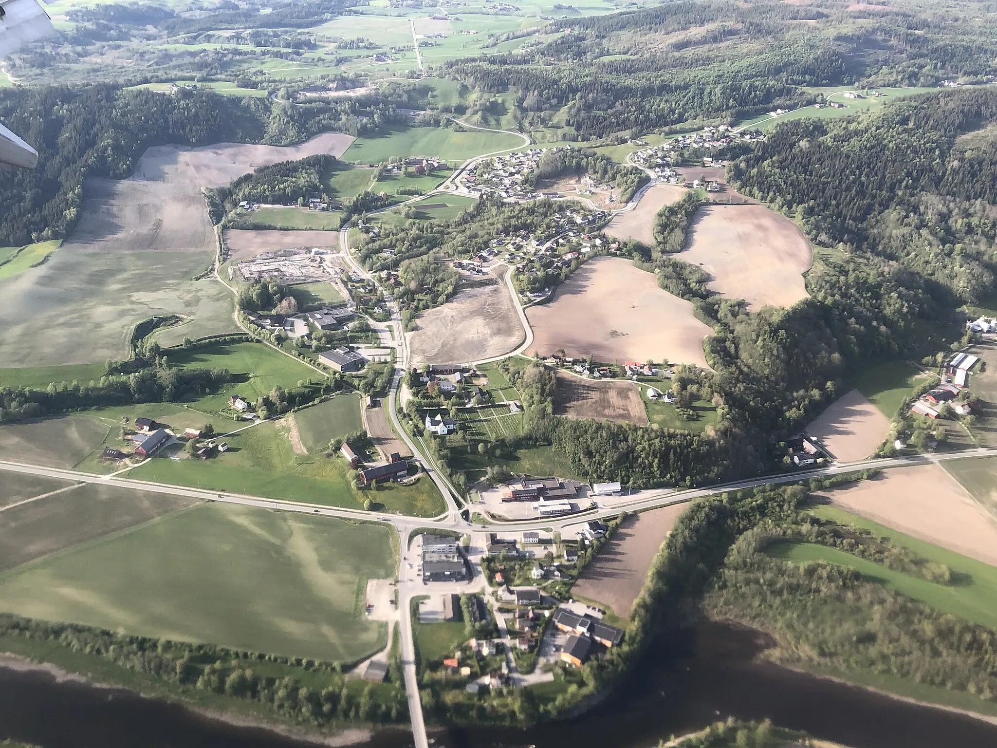 Photo showing: Hegramo (nederst i bildet), bygdesenter i Hegra i Stjørdal kommune i Trøndelag fylke, Norge. Nederst skimtes Stjørdalselva. Veien på tvers i bildet er Mellomriksveien (Europavei 14).