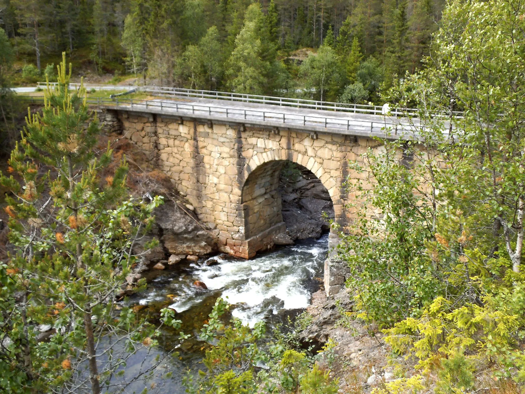 Photo showing: Eidet bru. An old stone bridge in Holtålen that was built in 1853. It crosses the river Gaula and is located near Hyttfossen.