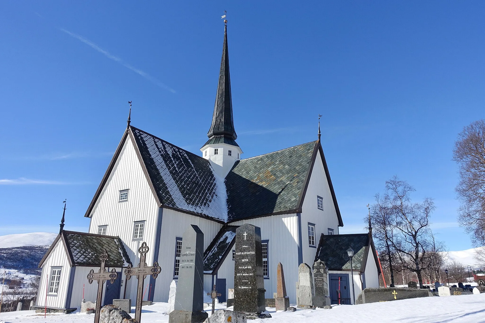 Photo showing: Oppdal Church (kirke, kyrkje, "Maret på Vang"), Gauldal deanery (prosti), Oppdal municipality, Trøndelag county, Norway. Built in cruciform style in 1651. Blue sky, snow, graveyard, view, etc. Photo 2019-03-19
