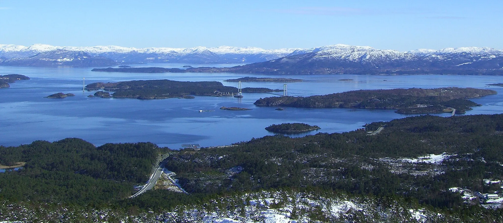 Photo showing: View of Bømlafjorden from Bømlo. To the left of the center is the island of Nautøy with Føyno behind it, and Spissøy to the right. The bridge to the left is Stord Bridge and in the middle Bømlo Bridge, both part of the Triangle Link