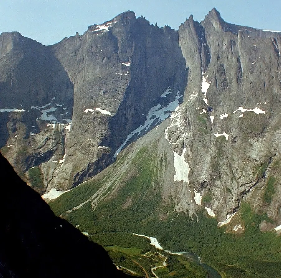 Photo showing: Trollveggen (Troll Wall) in Norway in June 2002. The picture is taken from the opposite ridge which is located to north from Romsdalshornet peak and to west from Vengedalen. The river valley down is Romsdal.