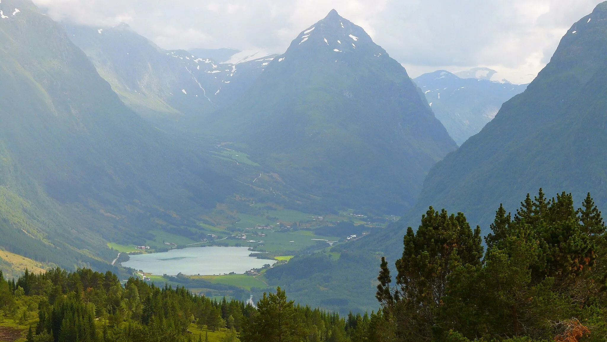 Photo showing: The valley of Votedalen as seen from a hill on Utvikfjellet in 2008 August. Utvikfjellet is located to the north from the village of Byrkjelo and the Riksvei 60 road is crossing the mountain near by (a litte to the east) the place this picture has been taken. The mountain in the center of the picture is Eggjenibba (1,338 m).