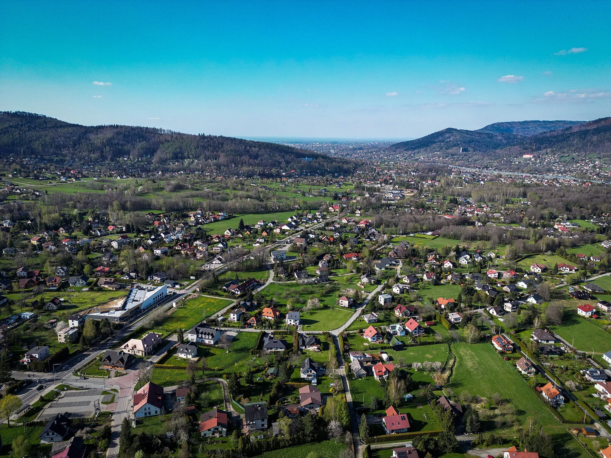 Photo showing: Meszna (Silesia) aerial view. In the central part there is a school and a kindergarten, in the background you can see Bystra. On the left a part of Kozia Góra, on the right Łysa Góra, between them Brama Wilkowicka.