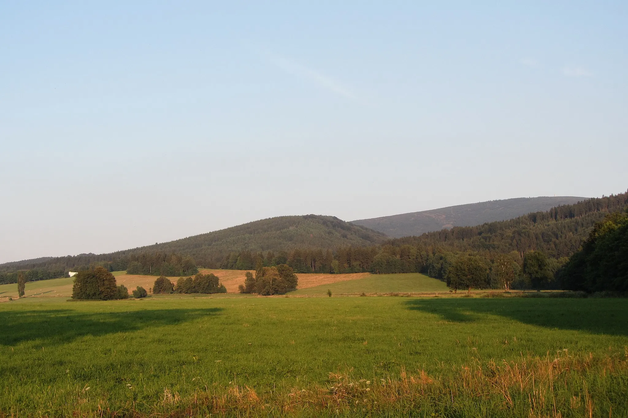 Photo showing: Vrch Měděnec (v pozadí jizerskohorský Smrk) při pohledu ze silnice mezi Ludvíkovem pod Smrkem a Novým Městem pod Smrkem.