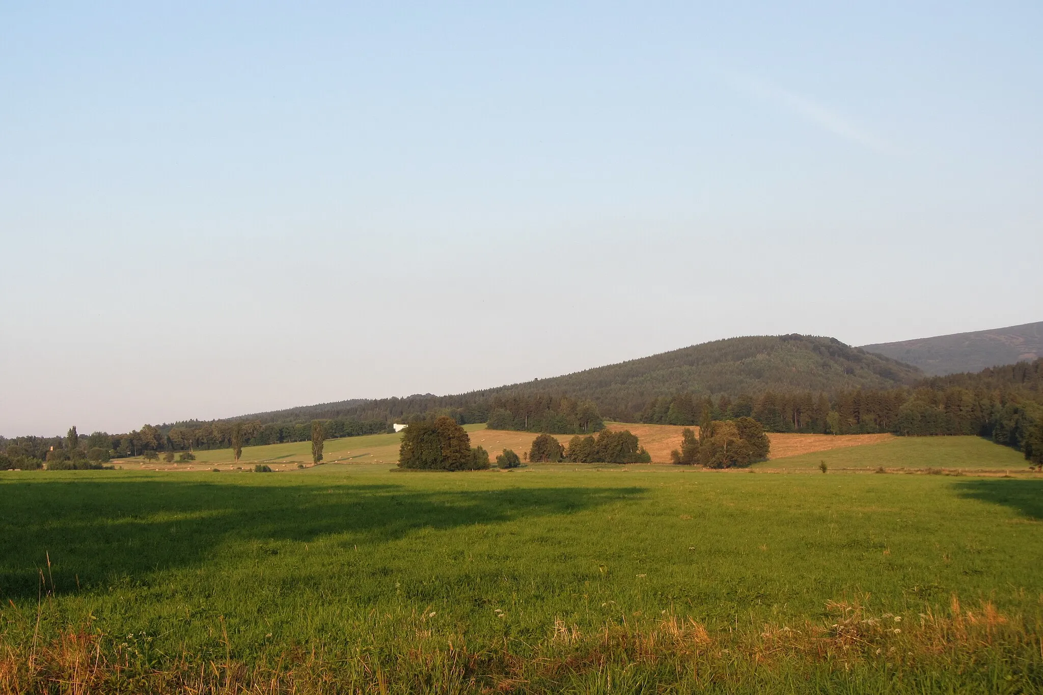 Photo showing: Vrch Měděnec (v pozadí vpravo jizerskohorský Smrk) při pohledu ze silnice mezi Ludvíkovem pod Smrkem a Novým Městem pod Smrkem.