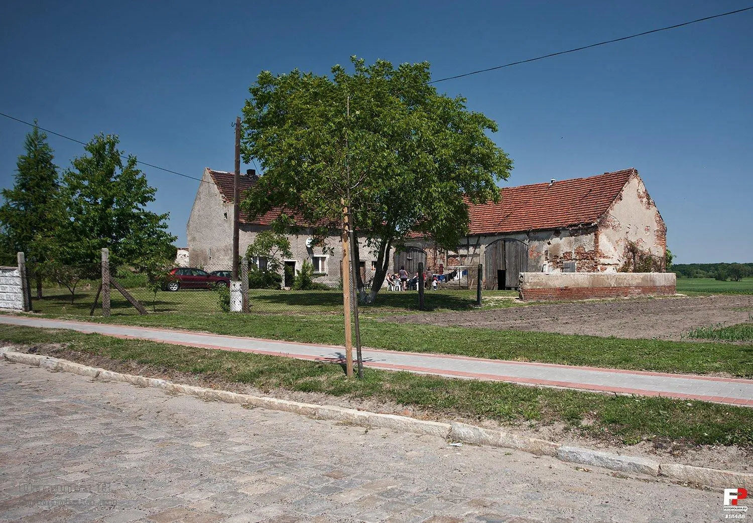 Photo showing: Ostatnie gospodarstwo we wsi po tej stronie drogi. Dalej drogą przez pola można dojść do stopnia wodnego.