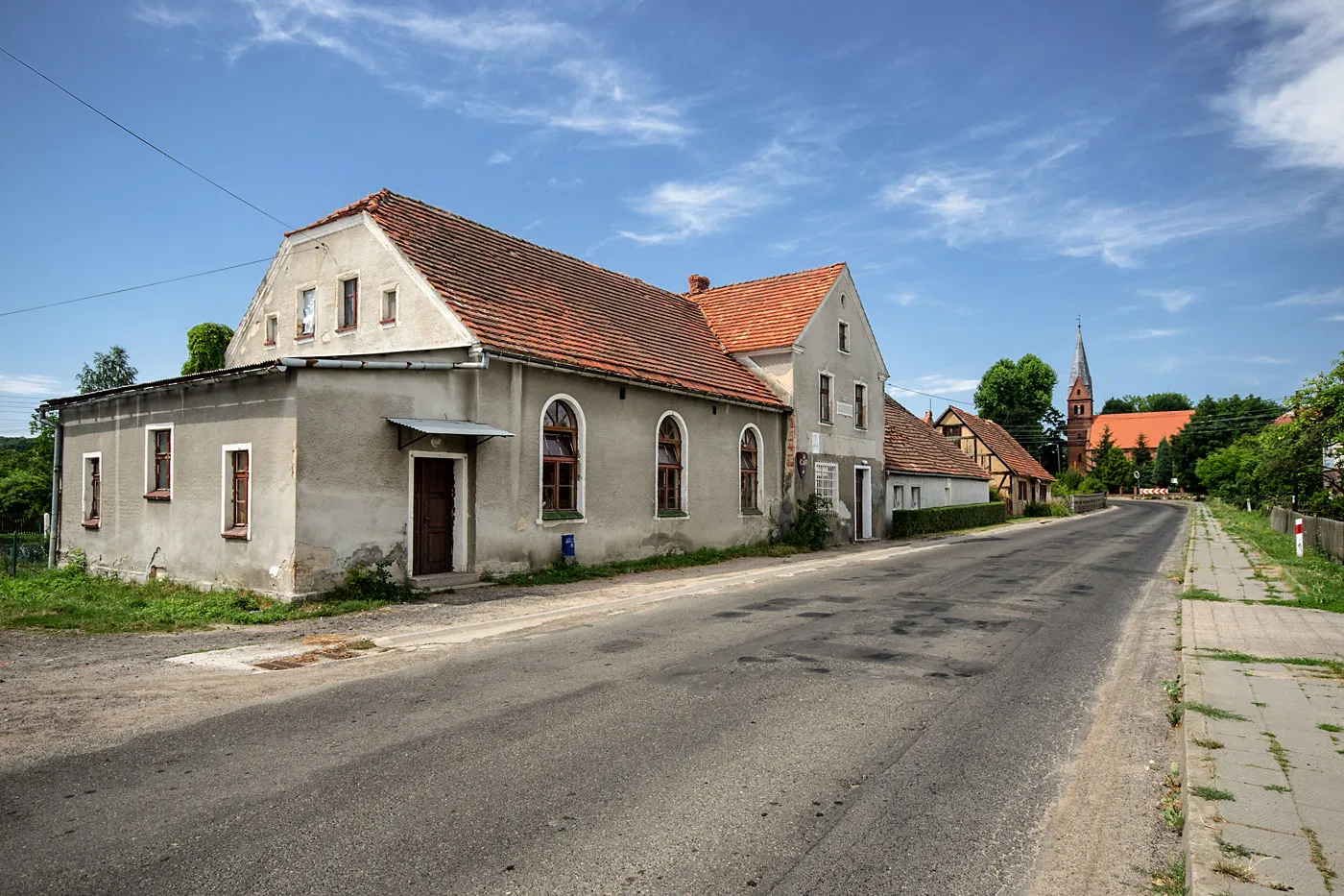 Photo showing: Wieś Baszyn w powiecie wołowskim, na pierwszym planie dawny gasthaus, w tle kościół św. Andrzeja Boboli