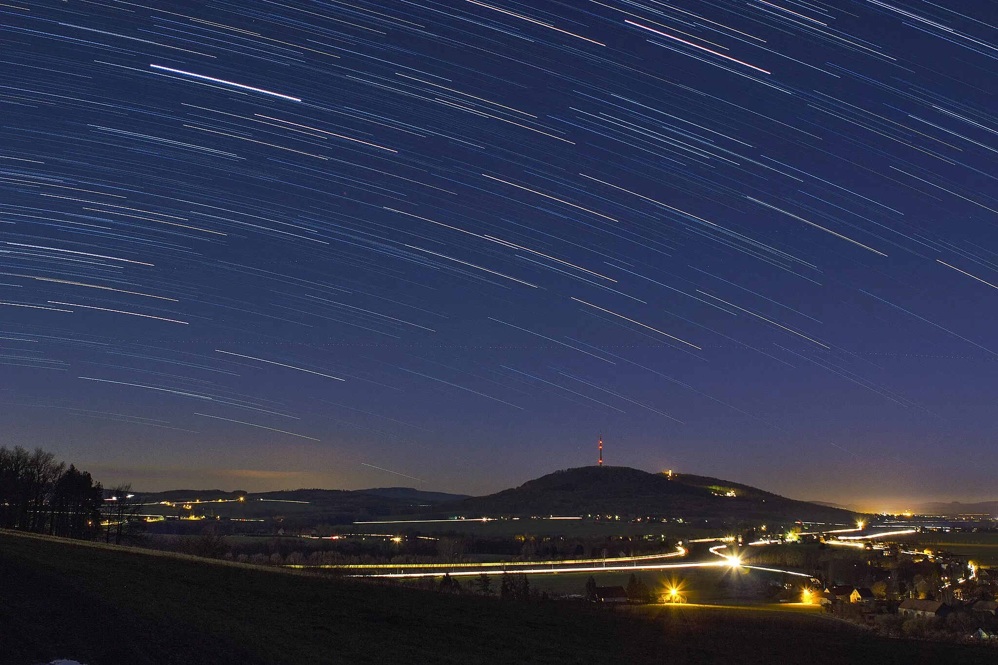 Photo showing: Eine Fotomontage aus 60 Aufnahmen à 29 Sekunden des Schafbergs und Löbauer Fernsehturms unter Sternenhimmel und bei aufgehendem Vollmond. Die zwei hellen Linien im Vordergrund zeigen die Bundesstraße B6 sowie die Bahnverbindung Löbau-Görlitz.