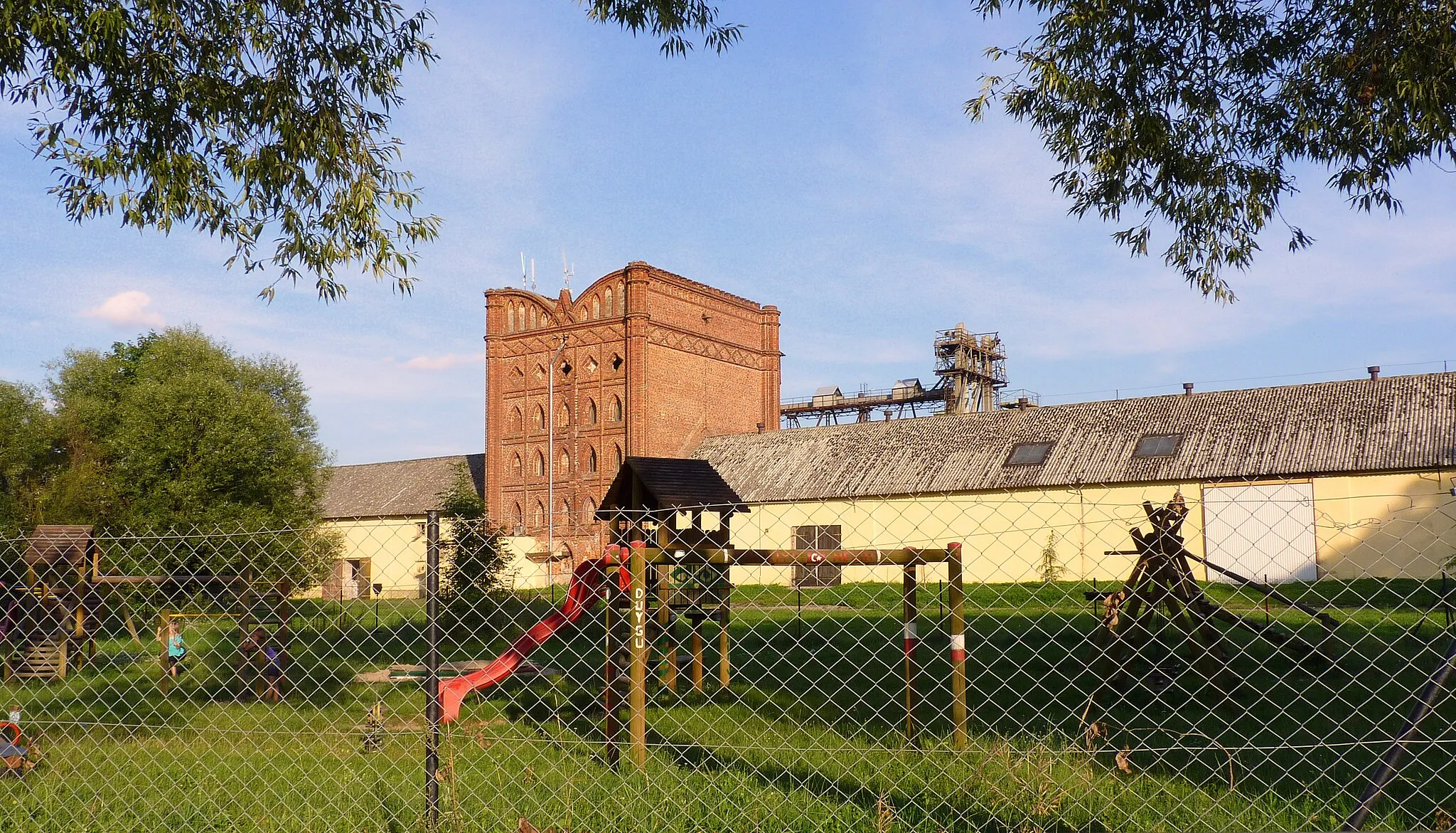 Photo showing: Lubostroń - plac zabaw dla dzieci a dalej stary budynek gospodarczy.