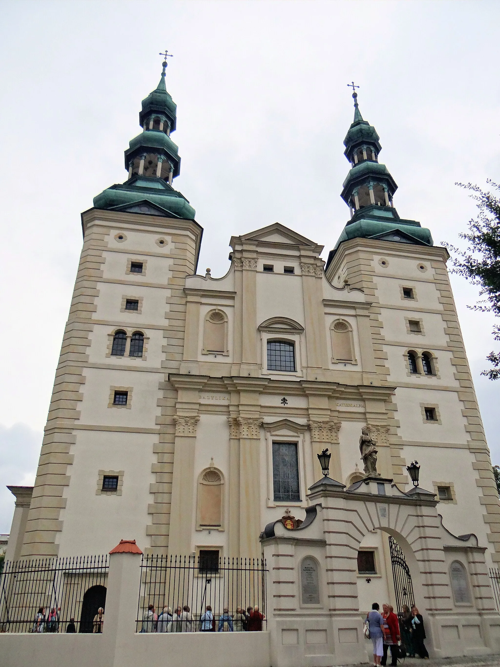 Photo showing: Bazylika Katedralna w Łowiczu - widok od strony zachodniej, od strony ul. Podrzecznej na bramę główną. Brama główna, zbudowana w 1907r, znajduje się na wprost portalu kościoła.