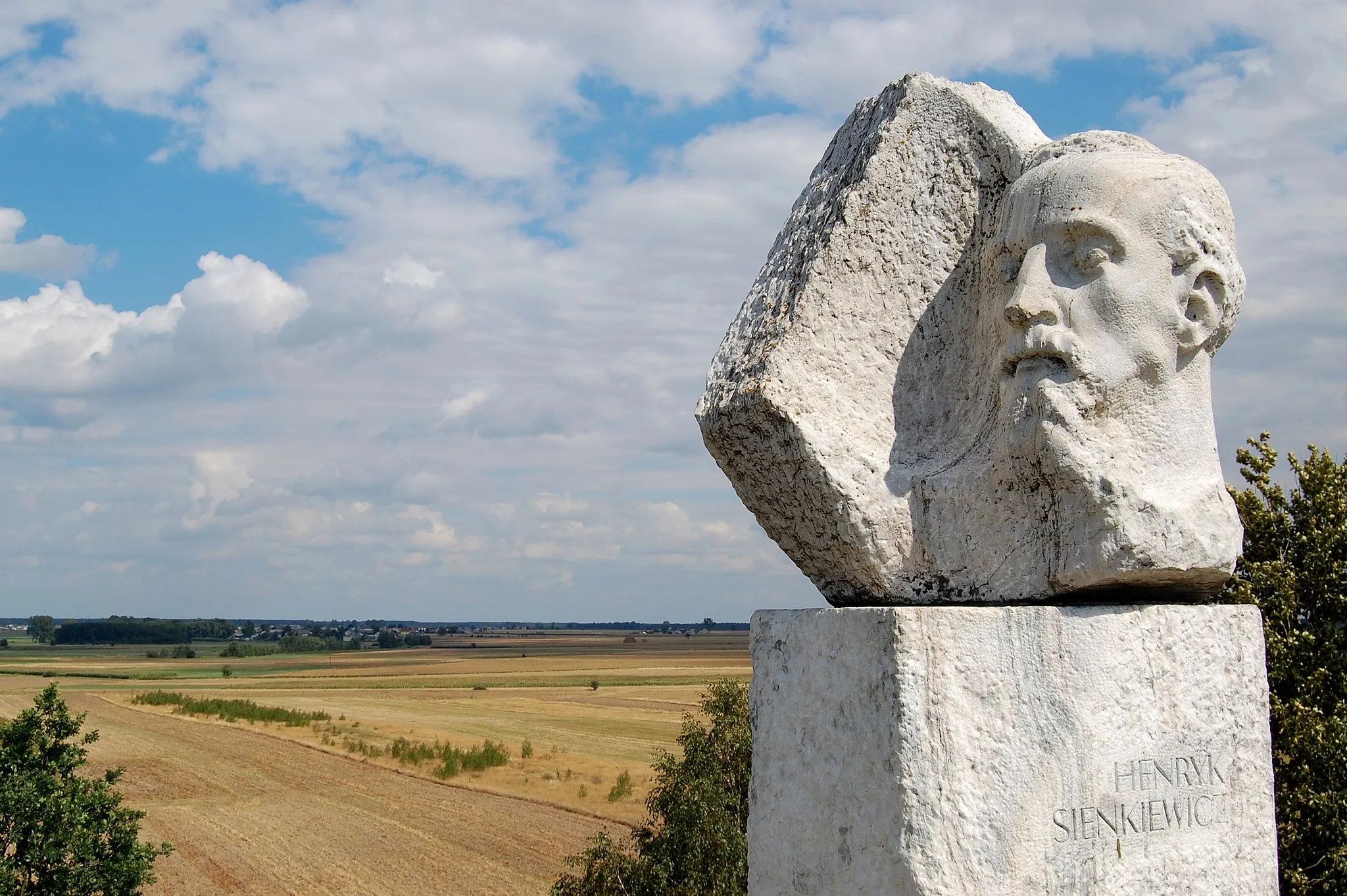 Photo showing: Monument of Henryk Sienkiewicz, Polish Nobel Prize-winning novelist and journalist, Okrzeja, Lublin Voivodeship, Poland. Village seen on the left side is Wola Okrzejska — writer's place of birth.