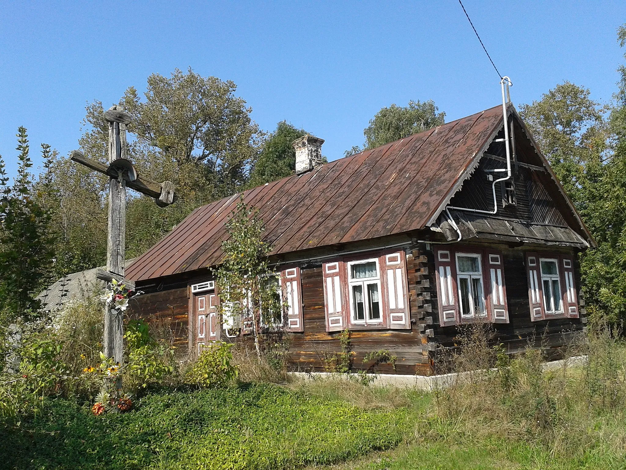 Photo showing: Drewniany budynek mieszkalny w Kożanówce i prawosławny krzyż przydrożny