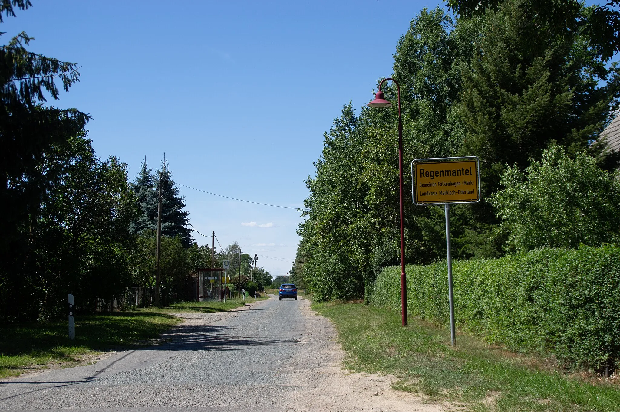 Photo showing: Falkenhagen (Mark), Ortsteil Regenmantel in Brandenburg. Das Ortsschild und der Beginn des Ortes.