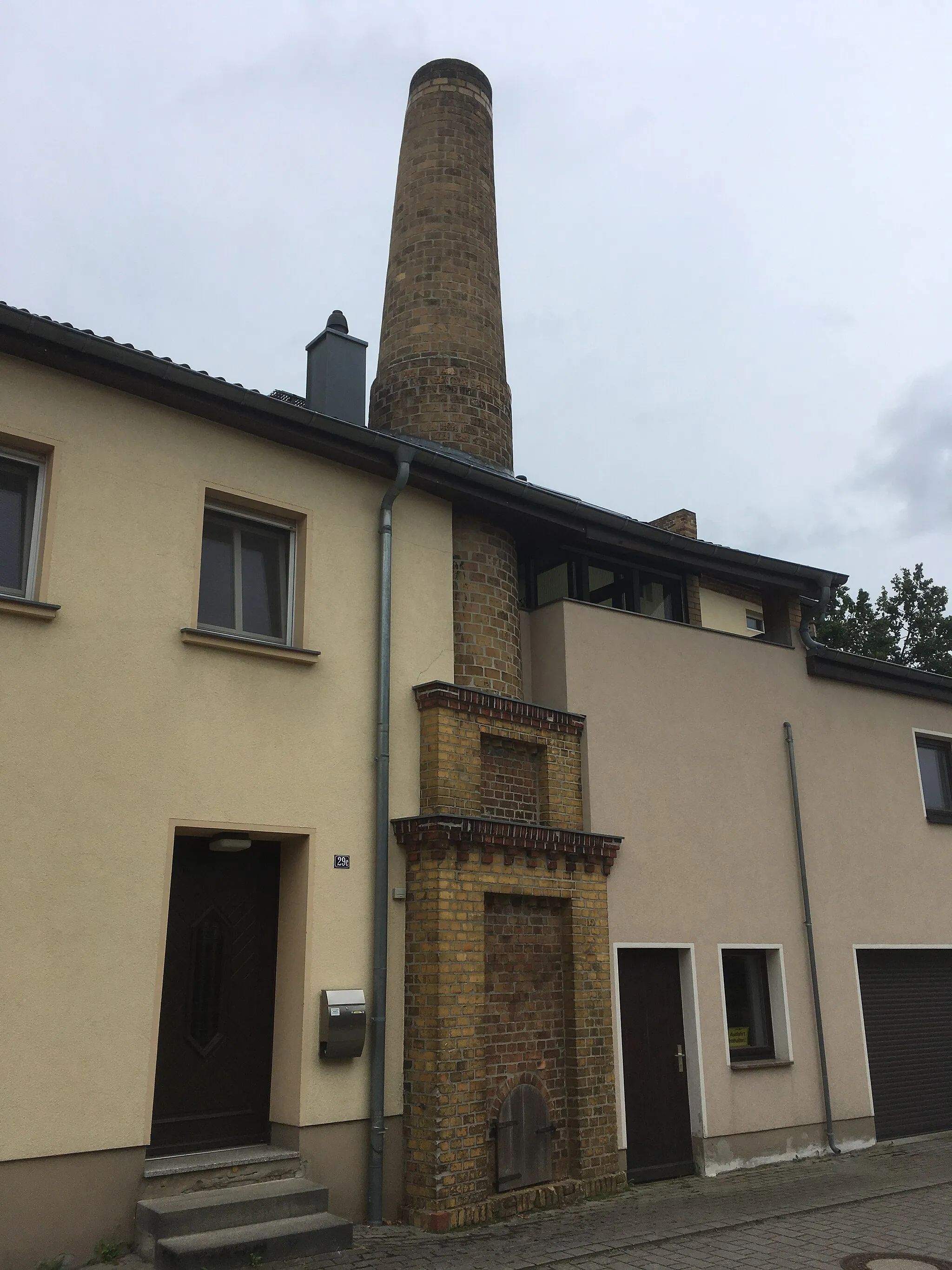 Photo showing: Chimney as a relic of a brewery in Schleife), Friedensstraße 29; around 1900; yellow clinker chimney, of importance for its building history and local history; cultural heritage monument