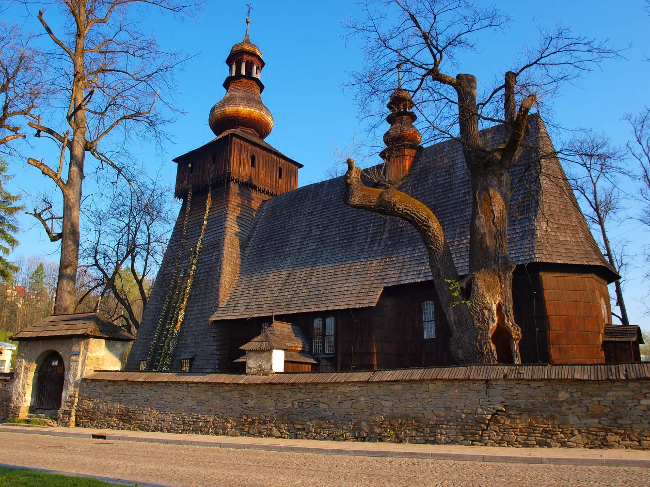 Photo showing: kościół p.w. św. Marii Magdaleny, drewniany obecnie Muzeum Orkana, ogrodzenie z bramkami, otoczenie, drzewostan