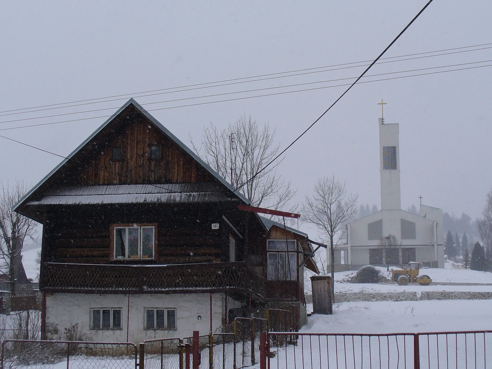 Photo showing: Oravská Polhora (Orawska Półgóra) w zimie. Drewniany dom góralski i nowy kościół