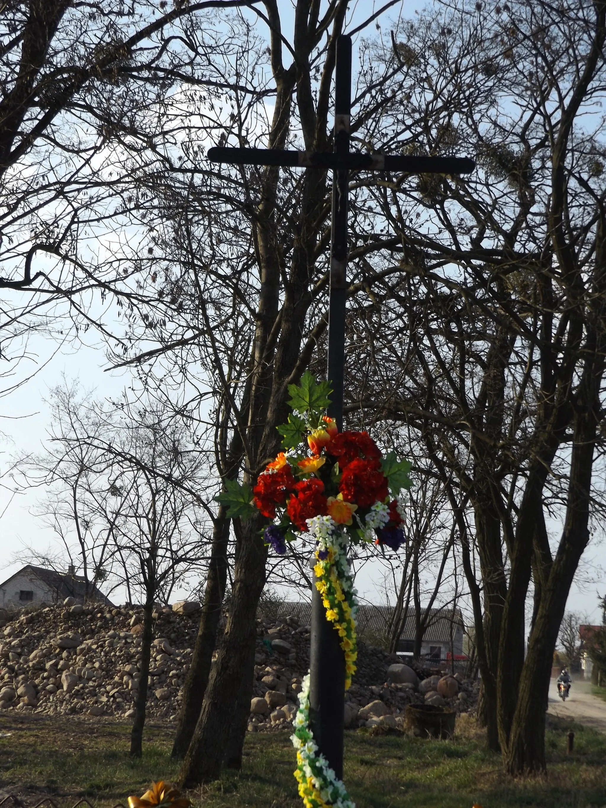 Photo showing: A metal cross with a metal figure, depicting the Crucified Jesus Christ; surrounded by a small, metal fence; located between two roads leading to the northwest (left to w:en:Gawarzec Dolny; right to centre of Gawarzec Górny), at the intersection of five roads on the border of the village in w:en:Gawarzec Górny (Czerwińsk nad Wisłą commune) in 2019 y.