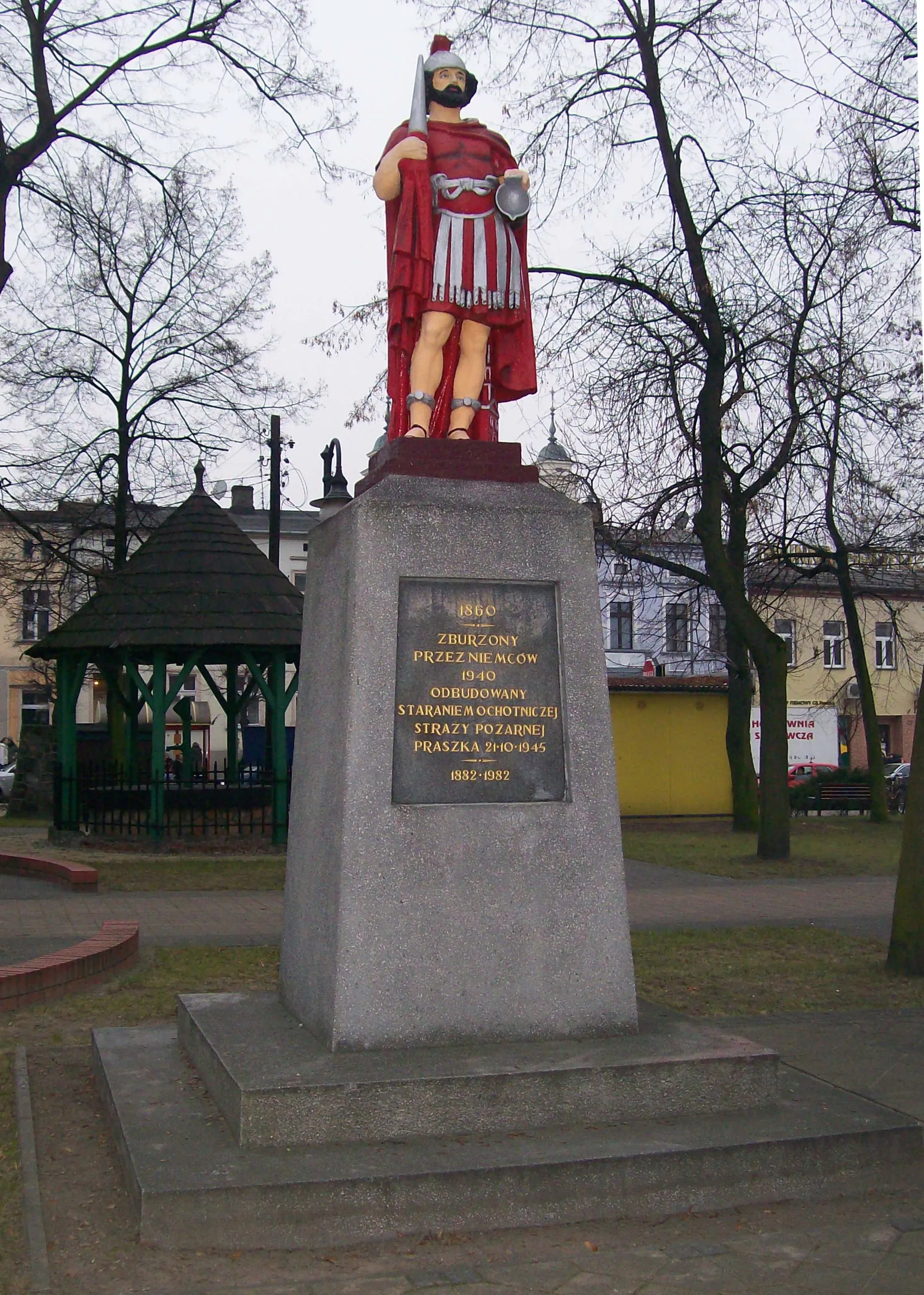 Photo showing: Pomnik św. Floriana w Praszce. Z lewej strony za pomnikiem tzw. "studnia życia."