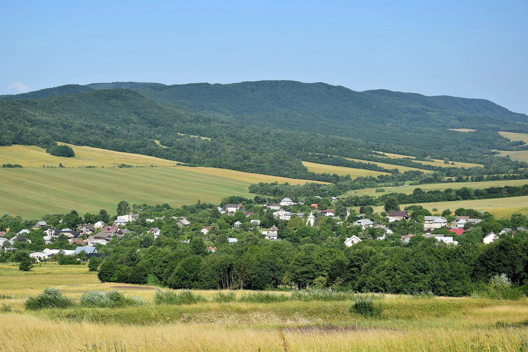 Photo showing: Kurimka – celkový pohled na vesnici z jihozápadního úbočí Makovice, v pozadí je hřeben Kohútova v Ondavské vrchovině