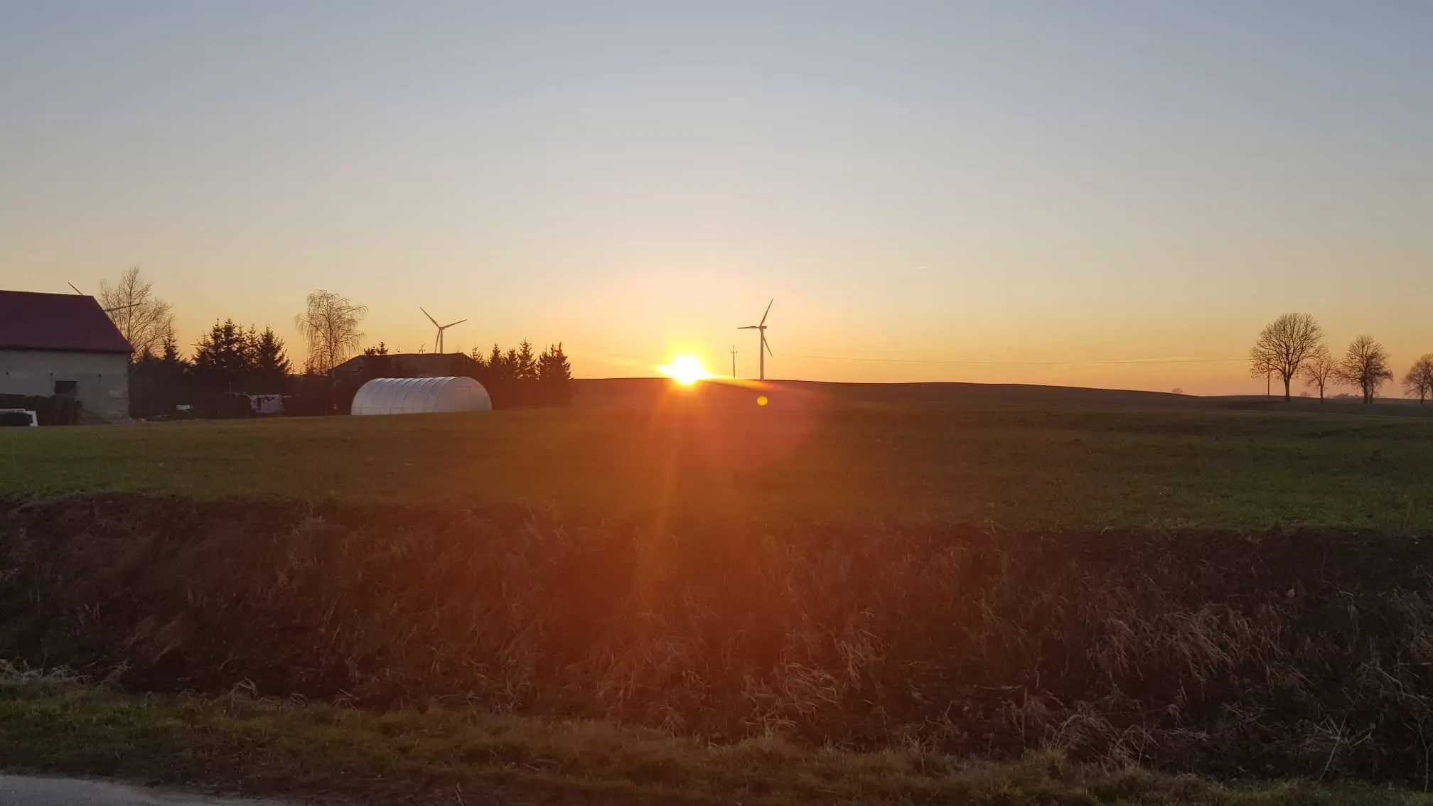 Photo showing: Wschód słońca w Gronajny. W tle widać turbiny wiatrowe.