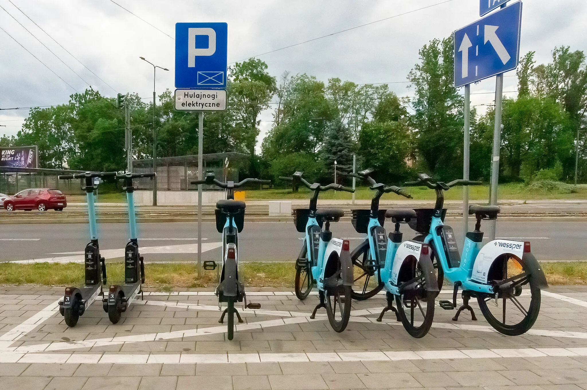 Photo showing: Electric scooters and electric bikes of the Roller network, parking for electric bikes and scooters, Sosnowiec, Centrum, ul. May 3, near the "Honeycombs" buildings