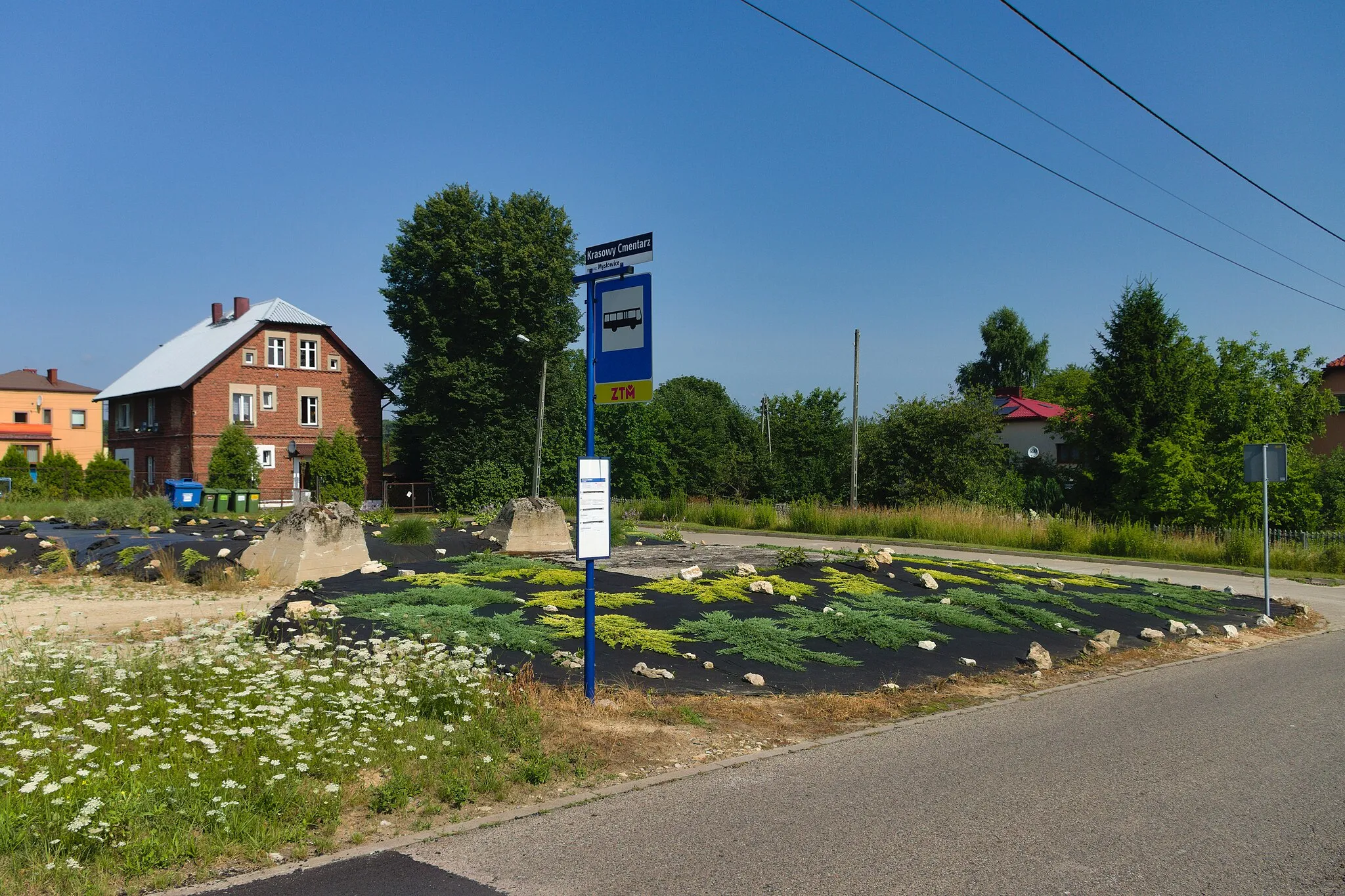 Photo showing: przystanek autobusowy Krasowy Cmentarz w Mysłowicach, w tle dekiel szybu (prawdopodobnie Barbara V) obsadzony roślinami i stopy fundamentowe zastrzału, z lewej ceglany budynek przy ul. PCK 221