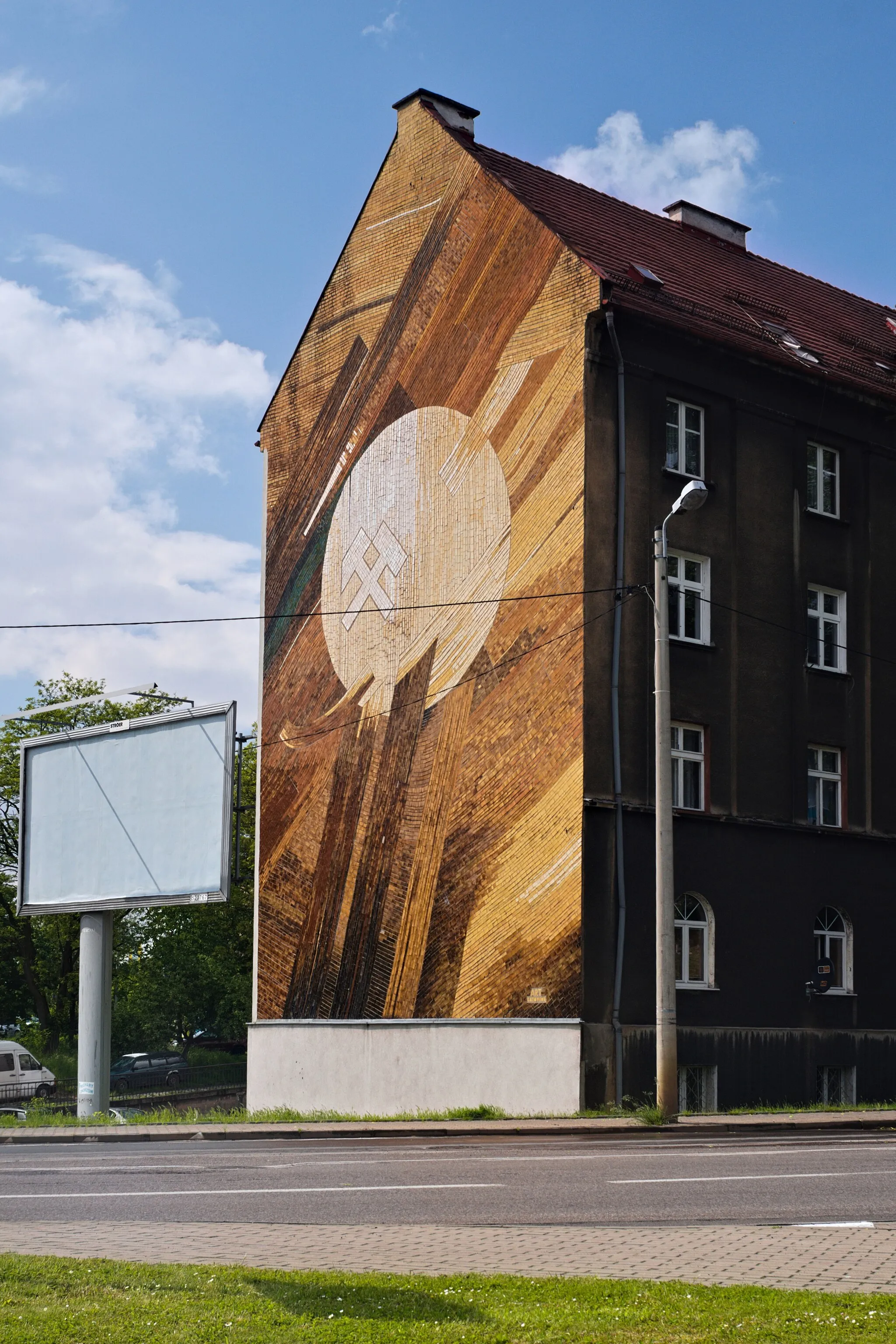 Photo showing: mozaika ceramiczna na ścianie budynku przy ul. 3 Maja 103d w Chorzowie, w centrum godłoo górnicze: pyrlik i żelosko, sygnowana w prawym dolnym rogu ART / KATOWICE; widok z południowego wschodu