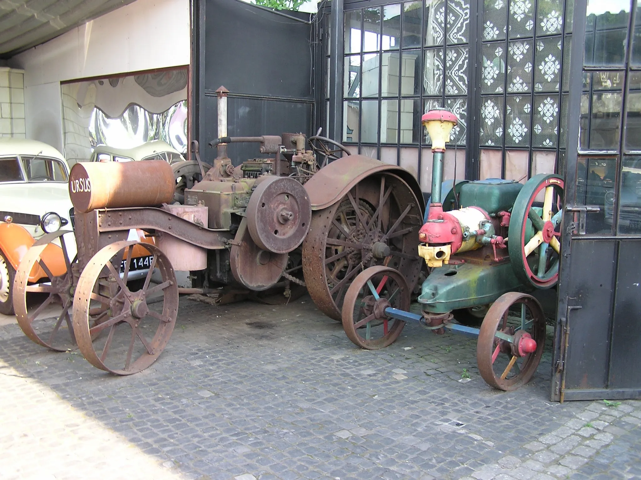 Photo showing: Titan Engine tractor in Otrębusy Museum near Warsaw (older unknown made locomobile on the right)