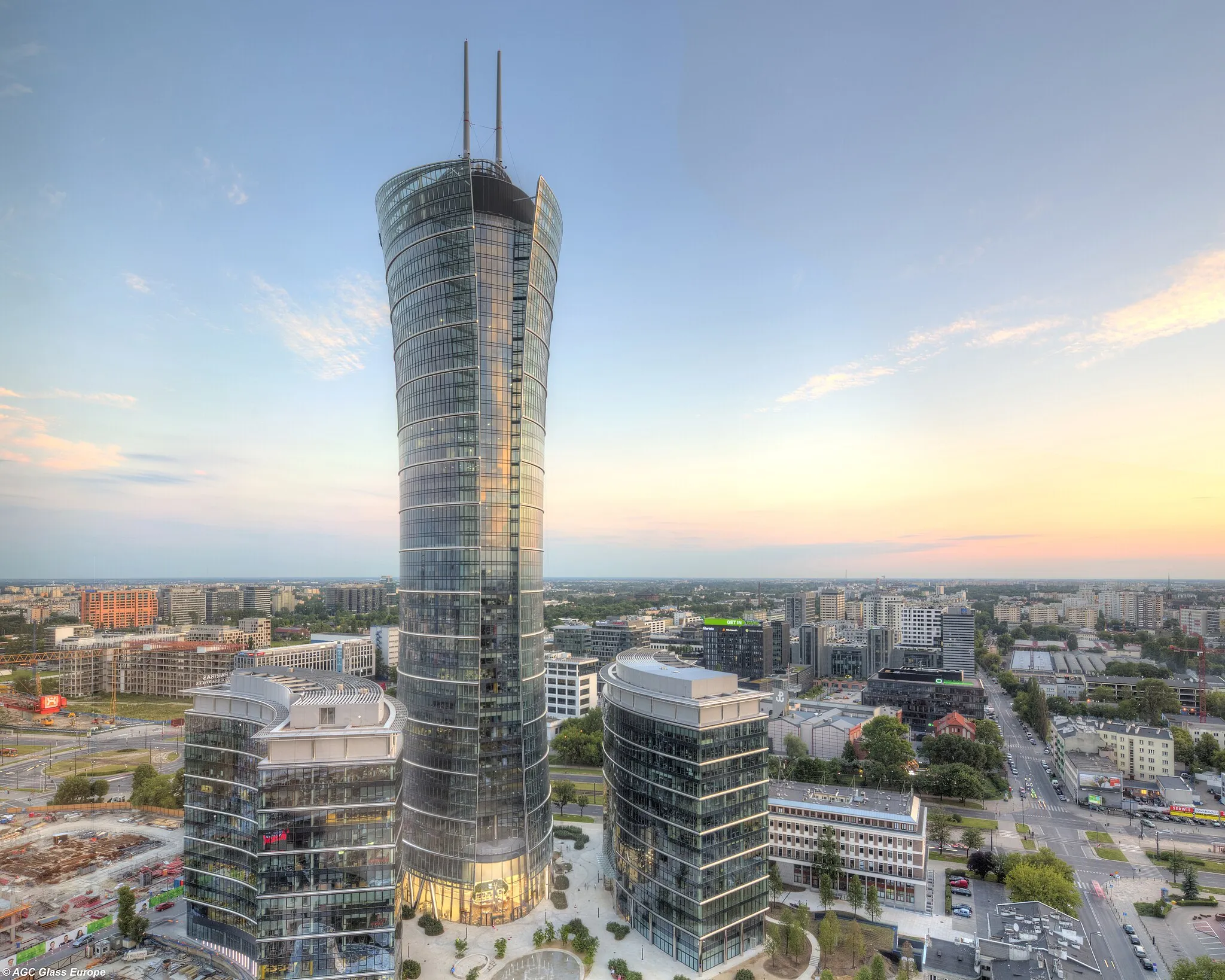 Photo showing: 1The Warsaw Spire is a complex of Neomodern office buildings in Warsaw, Poland constructed by the Belgian real estate developer Ghelamco. It consists of a 220-metre main tower with a hyperboloid glass facade, Warsaw Spire A, and two 55-metre auxiliary buildings, Warsaw Spire B and C. The main tower is the second tallest building in Warsaw and also the second highest in Poland.