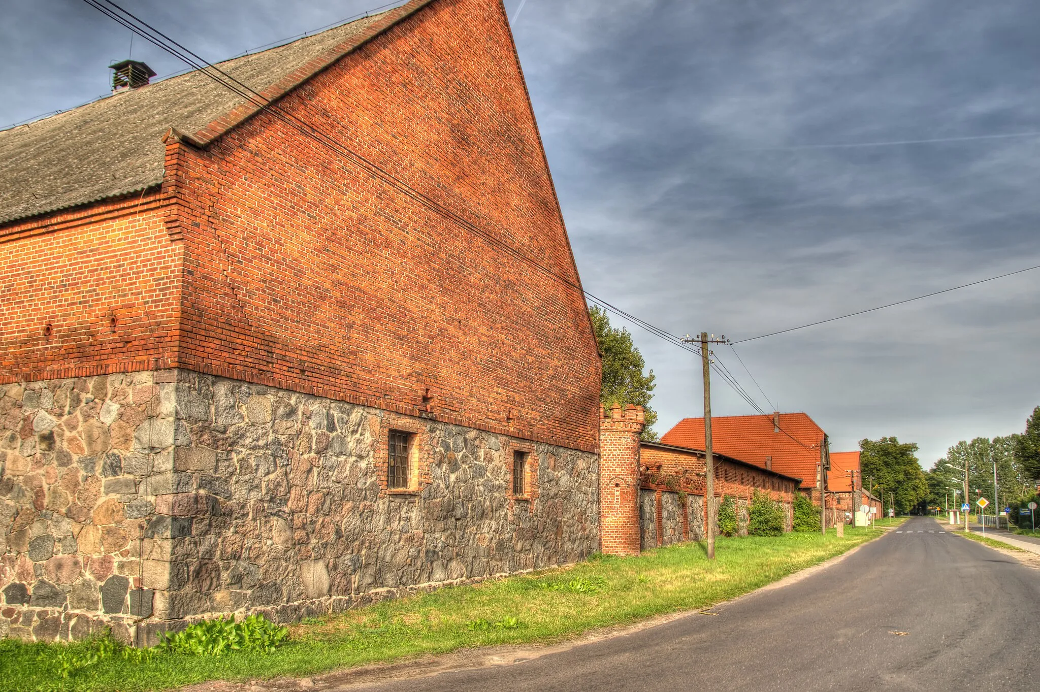 Photo showing: zespół folwarczny z 2. poł. XIX w.: 2 obory, kuźnia i stelmacharnia, gorzelnia z domem mieszkalnym, 2 stodoły, stajnia koni wyjazdowych, dom rządcy i stajnia koni roboczych, spichrz, cielętnik, mleczarnia, stajnia, ob. magazyn, garaż, garaż pługów parowych, wiata, ogrodzenie mur.
Wąsowo, ul. Parkowa 1, Kuślin