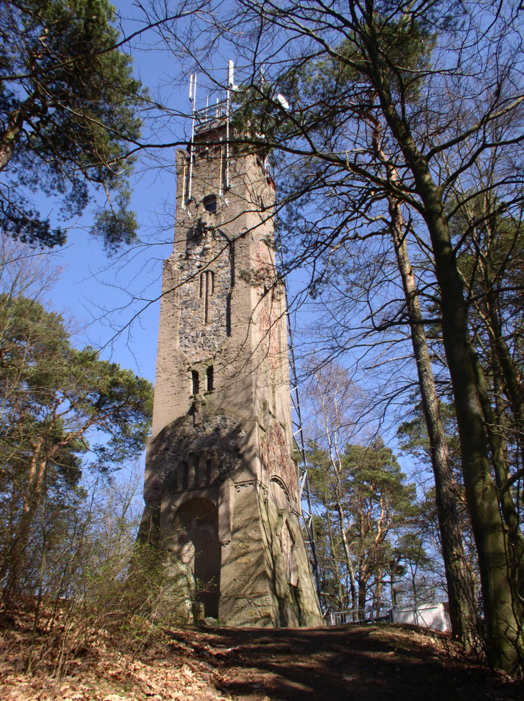 Photo showing: Wieża Bismarcka w Okonku niem. Ratzebuhr in Pommern (obecna nazwa Wieża Tecława) - stoi na Górze Tecława. Budowę tej 24 metrowej wieży zainicjowało Zrzeszenie Użyteczności Publicznej w Okonku pod przewodnictwem Naczelnika Poczty Ernsta Nitschke ze Szczecinka. Głównym wykonawcą prac budowlanych była firma Steltera z Okonka. Na miejsce budowy wieży wybrano, leżące na północ od miasta, Wzgórze Tecława (191 m.n.p.m.).
Kamień węgielny pod budowę położono 01.04.1908r. Koszt budowy wyniósł 12.000 marek, a całą inwestycję sfinansowano z dobrowolnych datków, loterii oraz reklamy. Za materiał budowlany posłużyła cegła i beton (wiązanie krzyżowe) oraz kamienie granitowe (mur cyklopowy). Drewnianymi schodami (86 stopni) można było wejść na platformę widokową. Na wieży przymocowano płaskorzeźbę Bismarcka z brązu, wykonaną w odlewni w Mannheim. Okna herbowe oprawiono kolorowym szkłem. Przed wieżą postawiono 4 metrowy pomnik obelisk z orłem ku czci poległych.

W uroczystościach poświęcenia wieży w dniu 23.08.1908r. udział wzięły liczne Związki i mieszkańcy Okonka, równocześnie odbyło się uroczyste odsłonięcie pomnika oraz nadanie "Orderu Orła" 4 klasy burmistrzowi Semmowi. Wieczorem na wieży dokonano inauguracyjnego rozpalenia "ognia ku czci Bismarcka".