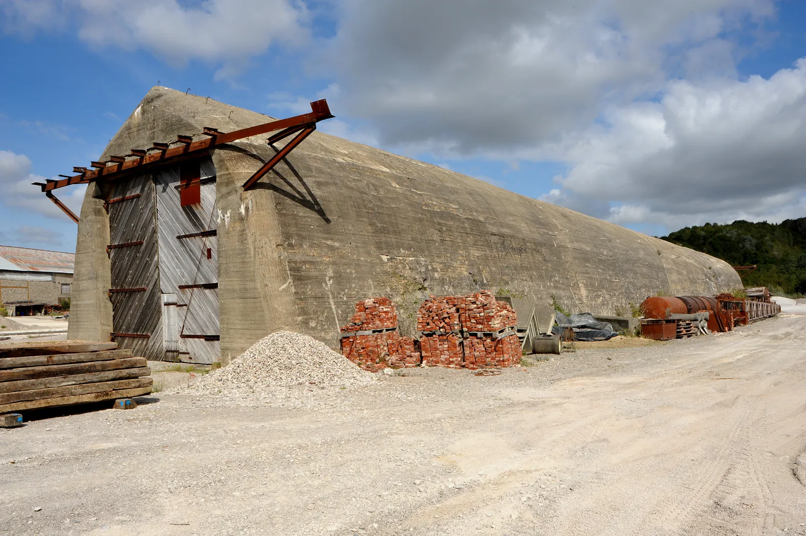 Photo showing: Dombunker for the German railway gun Krupp K5 (E) in the quarry near Hydrequent; later built in doors, from the original armoured doors only the mounting is remaining; at the rear end (right) were stocked since end of WW II till 2010 some of the steel plates for covering the cannon muzzles of the nearby V-3 site of Mimoyecques; Pas-de-Calais, France.