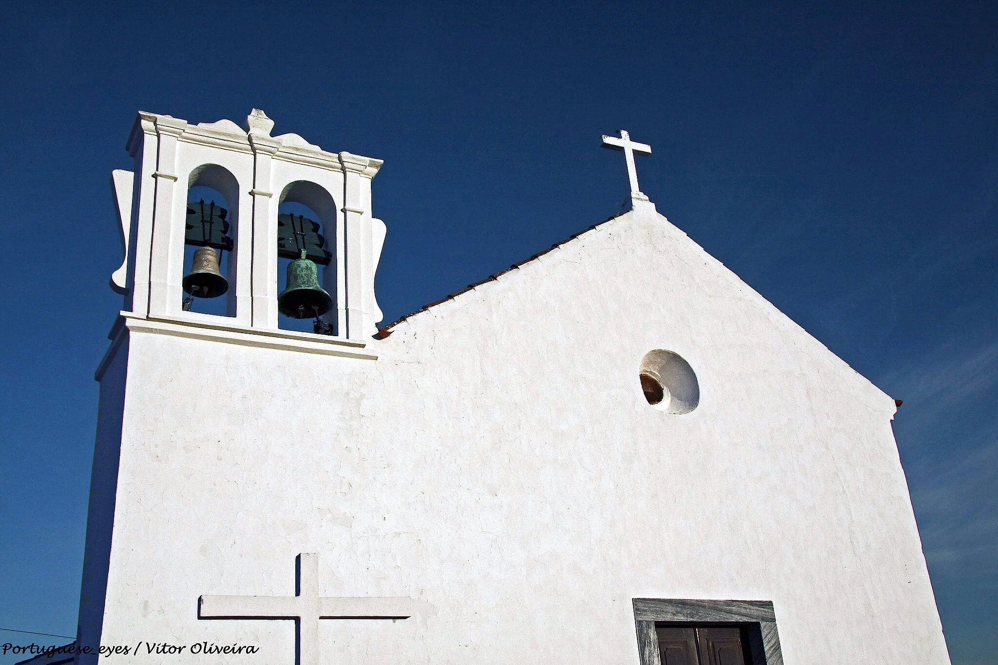 Photo showing: Data do 2º década do séc. XVII, e está num pequeno adro limitado por um muro baixo e um cruzeiro de pedra.
A Igreja é de PLANTA rectangular e é coberta por abobada de berço. Do lado do evangelho encontramos a capela baptismal de arco redondo com pia de pedra.
As paredes laterais são praticamente cobertas por pintura a fresco, colorido da época seiscentista atribuídos a um mestre desconhecido do ciclo tardo-maneirista bejense ou eborense, com destaque para a pintura a fresco do painel de S.Tiago Mata Mouros a cavalo e do painel do Purgatório com o Arcanjo S. Miguel.
O arco do triunfo apresenta na parte superior motivos florais e na parte inferior um alto lambril imitando azulejos de padrão enxaquetado, que continua na parede da parte inferior da capela-mor. Na parte superior das paredes da capela-mor reconhem-se os 4 Evangelistas e Anjos Músicos.
Situada em Faro do Alentejo.
O Altar – mor de talha policromada, barroca com um nicho envidraçado onde se venera ainda um Cristo Crucificado, imagem do séc. XVII.

Dois altares ladeiam o arco do triunfo em urnas de alvenaria de madeira - em azul e branco, ambas da N Sra. do Rosário. bookhotelspain.com/igreja_matriz_de_s_luis_faro_do_alente...