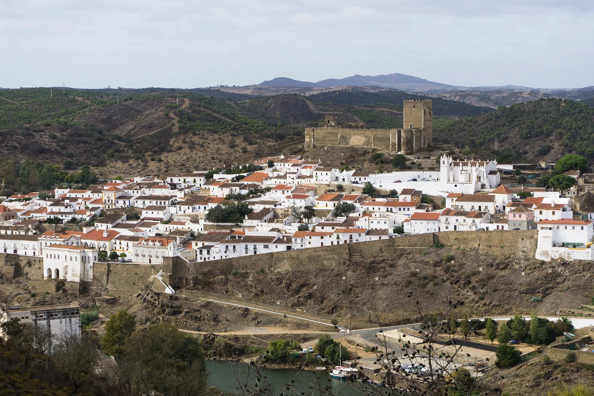 Photo showing: Mértola viewed from the opposite shore of the Guadiana, with the city wall and the medieval castle uphill, 10th November 2019