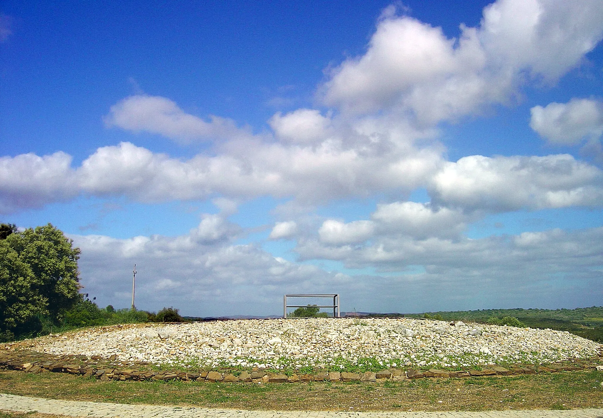 Photo showing: Os Monumentos megalíticos de Alcalar são um conjunto de 18 túmulos megalíticos agrupados em vários núcleos e com uma grande diversidade arquitectónica. Situada entre o norte da ria de Alvor e o sopé da serra de Monchique, esta necrópole data do III milénio a.c.
Destes monumentos, o catalogado como "monumento nº7" é o mais bem conservado e, por esse motivo, é o que está aberto ao público para visita. Este encontra-se situado a leste da estrada para a Senhora do Verde, e está localizado no cimo de um outeiro.
O "monumento nº7" é constituído por um cairn, que consiste em uma mamoa de pedras que envolve um tholos. O tholos, por sua vez, é uma construção com um corredor e cripta coberta em falsa cúpula e foi utilizado, durante a segunda metade do III milénio a.c., como sepúlcro e local de culto.
Os visitantes dispõem de um Centro de Acolhimento e Interpretação onde está patente uma exposição permanente sobre o "sítio". O percurso da visita encontra-se devidamente sinalizado.
Para quem se deslocar até estes monumentos recomenda-se, no mínimo, uma visita aos menires e cistas megalíticas da serra de Monchique. Se o tempo não for problema pode aproveitar para visitar a igreja de S. Sebastião, em Lagos, a igreja do Divino Salvador, em Portimão, e a villa romana da Abicada, também em Portimão www.netparque.pt/NPShowStory.asp?id=264591

See where this picture was taken. [?]