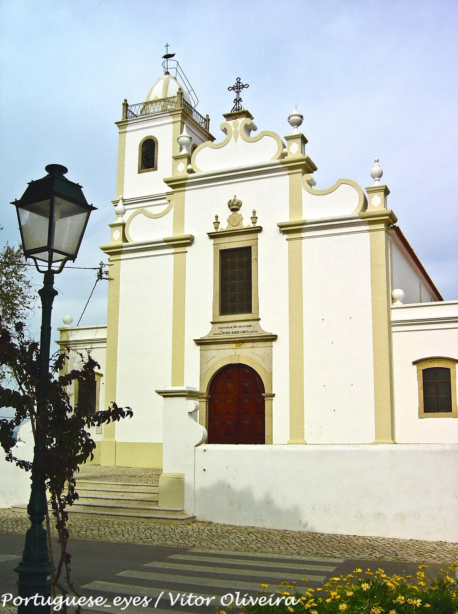 Photo showing: A Igreja Matriz de Porches é uma igreja situada na freguesia de Porches, concelho de Lagoa, Portugal.
Igreja Matriz de Porches.
Erguida no século XVI, a Igreja Matriz de Porches tem, hoje em dia, poucos elementos dos seus traços primitivos. Da antiga Igreja, arruinada pelo terramoto de 1755, resta apenas a Capela-Mor, incorporada no templo actual, e que foi alvo de remodelações em 1882.
Exteriormente esta é uma bela peça de arquitectura religiosa, apresentando uma fachada sóbria voltada a Poente. No interior, são dignos de menção a Capela-Mor, dedicada a Nossa Senhora da Encarnação, com uma abóbada de nervuras revestida a magníficos azulejos do século XVIII e o retábulo do altar-mor em talha dourada onde figuram imagens do século XVIII.
pt.wikipedia.org/wiki/Igreja_Matriz_de_Porches

See where this picture was taken. [?]