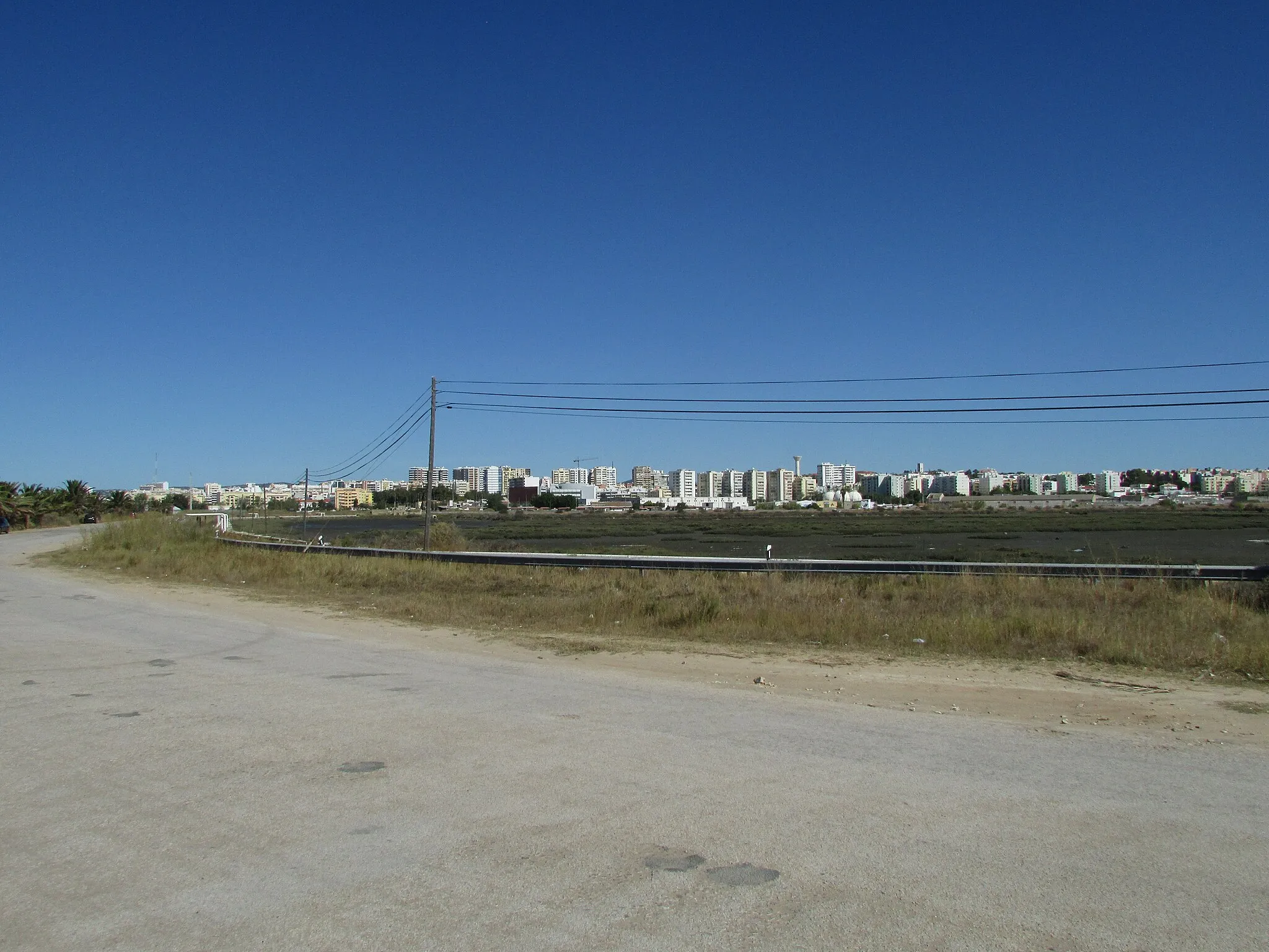 Photo showing: A view across the Ria Formosa towards the city of Faro from the Estrada do Cais Comercial south of the city of Faro, Algarve, Portugal.