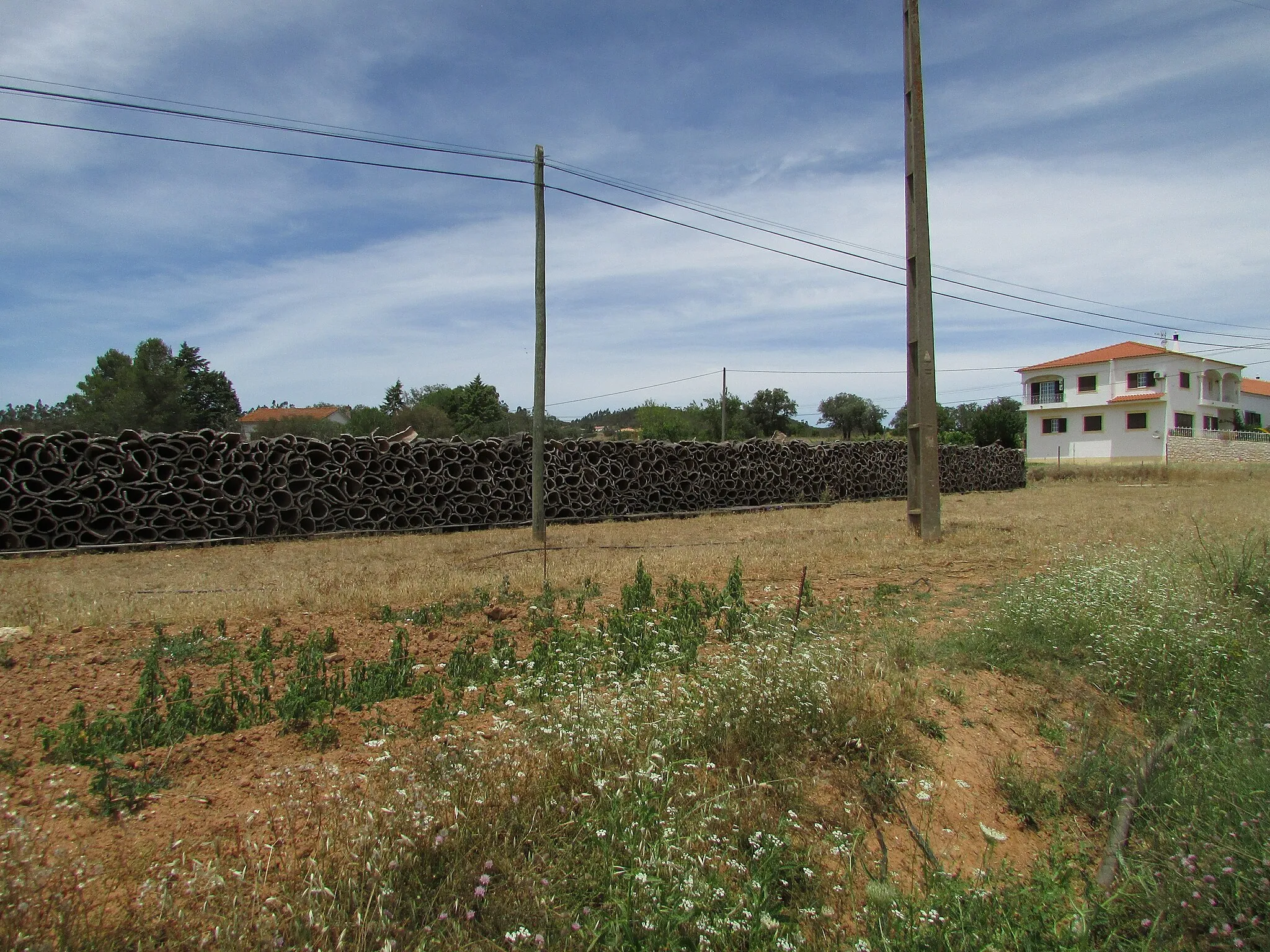 Photo showing: A stack of harvested cork next to the EM510 road near the village of Foz do Ribeiro near São Bartolomeu de Messines, Silves, Algarve, Portugal.