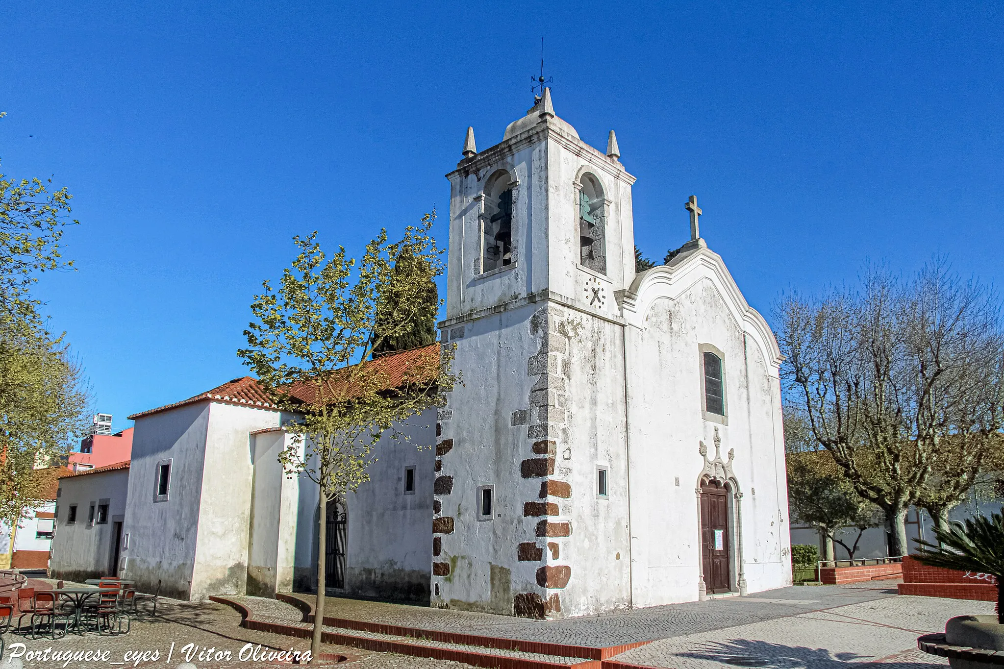 Photo showing: O atual templo de Nª Sª da Graça resulta de sucessivas intervenções efetuadas desde que a pequena Ermida desta invocação foi erigida pela população local, provavelmente, em meados de quatrocentos.
A Igreja, de traça quinhentista, apresenta-se como um dos raros monumentos da arquitetura manuelina no concelho. De nave única, o edifício apresenta duas Capelas funerárias laterais, de planta quadrada, com abóbadas de nervuras tão ao gosto quinhentista e desta época conserva ainda alguns painéis de azulejos enxaquetados, brancos e verdes.
A decoração exterior da fachada principal apresenta um programa decorativo definido pelo portal axial em pedraria, cujo arco trilobado arranca de finas colunas de bases e capitéis lavrados, ornados por elementos vegetalistas e coroados por cogulhos dispostos em triângulo.
A vivência ao nível local de uma elite de altos funcionários da Coroa relacionados com a Real Fábrica do Biscoito em Vale de Zebro, que decisivamente deixou marcas da sua existência na velha Ermida, foi determinante para a importância que a freguesia viria a assumir no contexto da Expansão Portuguesa.

A Igreja de Nª Sª da Graça foi classificada como Monumento Nacional em 1922. www.cm-barreiro.pt/conhecer/patrimonio-historico-cultural...