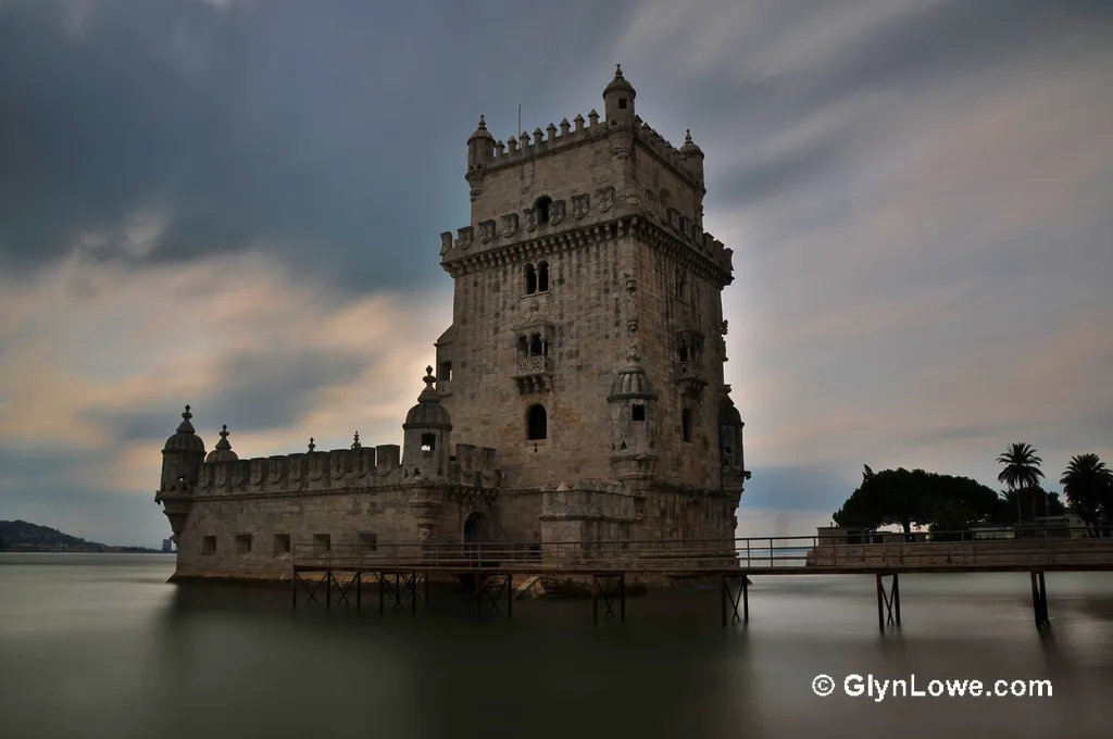 Photo showing: Local Name: Torre de Belém, The Torré de Belém is certainly Lisbon's most famous construction and at the same time most well known symbol. It stands surrounded by lawns on the bank of the Tagus to the west of the Hieronymite monastery. At this point the Tagus widens into a large bay.
Originally conceived as a lighthouse and simultaneously a defensive fortress for the port of Restelo, Manuel I had the tower built in 1515 on a small island off the river bank. Many old views of the city show the Torré de Belém at a distance from the mainland surrounded by the waters of the Tagus. A former, older tower on the opposite bank and Belém's fortress tower were supposed to afford maximum protection for the harbour. A general shift in the location of the river bank has resulted in the tower now standing on the mainland right on the water's edge: a footbridge leads across an artificial basin to the entrance to the tower.
Francisco de Arruda began the construction in 1515. De Arruda came from Alentejo and was one of the most famous architects to use the Manueline style. He had studied with his older brother Diogo de Arruda, had then worked for some time in north Africa and was thus acquainted with the elements of the Arabic style - one of the reasons for the obvious Moorish influences in his work.

The Torré de Belém has been the setting for many historical events. These included the onset of Spain's 60 year rule of Portugal after the conquest of the tower in 1580. After Lisbon was taken by Napoleonic troops in 1807 the two upper stories of the tower were destroyed and wooden houses built in their place. In 1845 Minister Terceira had the tower restored to its original state.