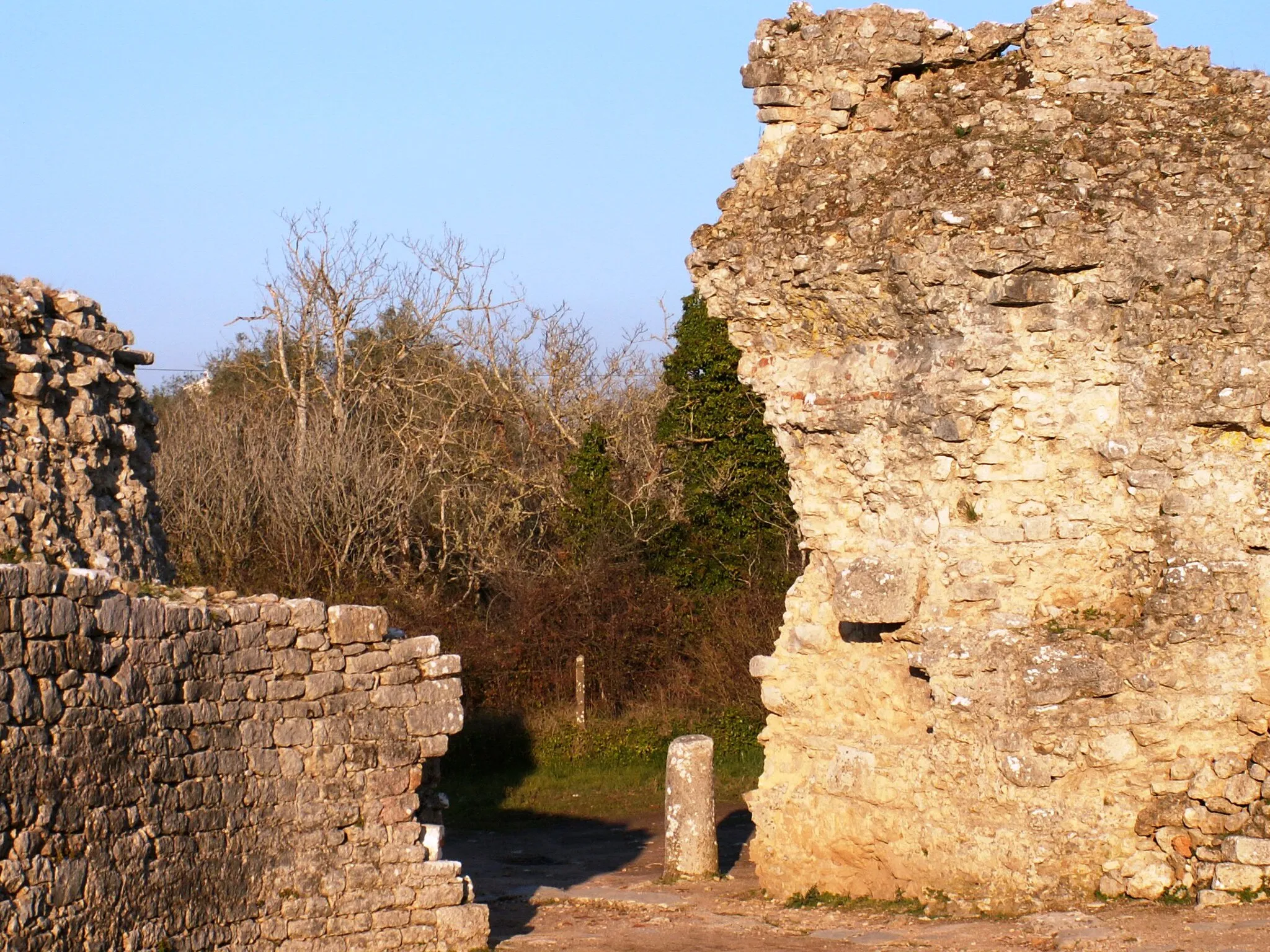 Photo showing: Ruins of a roman gate in Conímbriga.
Conímbriga is one of the largest Roman settlements in Portugal, and is classified as a National Monument. Conímbriga lies 16 km from Coimbra (the Roman Aeminium) and less than 2 km from Condeixa-a-Nova.
The name Conimbriga derives from an early, possibly pre-Indo-European element meaning "rocky height or outcrop" and the Celtic briga, signifying a defended place. Others think that the element coni may be related to the Conii people.
When the Romans arrived, in the first half of the 2nd century BC, Conímbriga was a flourishing village. Thanks to the peace established in Lusitania a quick Romanisation of the indigenous population took place and Conímbriga became a prosperous town. Judging by the capacity of the amphitheater, the city had an estimated population of 10600.
Following the deep political and administrative crisis of the Empire, Conímbriga suffered the consequences of the barbaric invasions. In 465 and 468, Sueves captured and partially plundered the town already abandoned by part of its population, that fled to the nearby town of Aeminium.
The city walls are largely intact, and the mosaic floors and foundations of many houses and public buildings remain.

Source: Wikipedia
