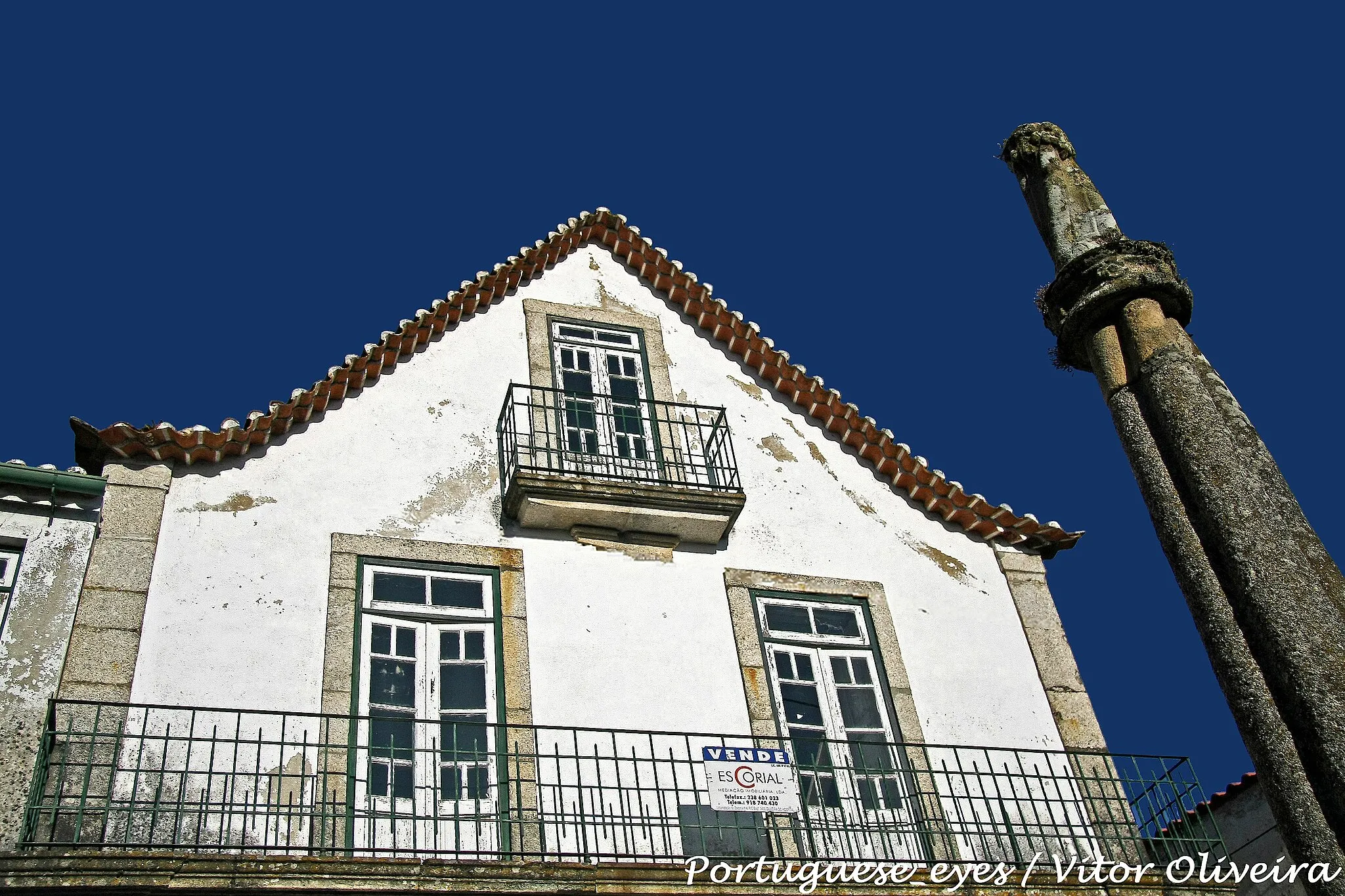 Photo showing: Midões, ou Midães, designação medieval do antigo concelho, foi em parte couto do Mosteiro de Lorvão, de onde lhe chega a toponímia do "Coito", e de cujo senhorio há notícias desde o século X, e em parte pertença do Cabido da Sé de Coimbra. É a mais antiga localidade do concelho de Tábua, no qual foi integrada em 1853. Teve foral manuelino, dado em 1514, e na sequência do qual terá sido erguido o pelourinho, que ainda se levanta em praça central da pequena povoação, diante de uma interessante casa seiscentista (dos Sousa Machado).
O pelourinho levanta-se sobre um soco de dois degraus quadrangulares muito rústicos, de pedra aparelhada e aresta viva, encimado por um prisma quadrangular liso, onde assenta a coluna. Esta possui base quadrada dupla, talhada no mesmo bloco do fuste, de cuja parte superior irrompem quatro toros lisos, que seguem na vertical, sem torção, mas com ligeira curvatura, de forma a compôr uma coluna com ligeira entasis . O capitel é formado por duas molduras anelares salientes, mediada por gola decorada com quatro rosetas. O remate consta de um pináculo espiralado, vagamente tronco-cónico, encimado por um ornamento do tipo cogulho. SML www.igespar.pt/pt/patrimonio/pesquisa/geral/patrimonioimo...

See where this picture was taken. [?]