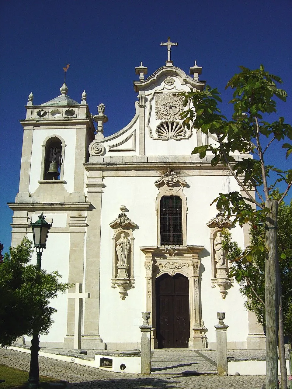 Photo showing: Considerado um dos mais belos templos da região, a Igreja Paroquial do Divino Espírito Santo, de Monsanto, é um edifício de estilo barroco, com uma imponente fachada, de grande equilíbrio e excelentes proporções, datado de 1768.
O portal sobrepujado do janelão do coro abre-se entre dois nichos baldaquianos, onde se vêem as imagens de S. João Evangelista e de Nossa Senhora da Conceição, em pedra, quase de tamanho natural, formando o Calvário. No frontão figura, em baixo relevo, o Espírito Santo sob um dossel de pedra. À esquerda eleva-se a torre sineira, bem proporcionada.
No interior do templo, é de referir a bonita capela-mor e a representação, em pedra, da Santíssima Trindade, datada do século XVII. www.cm-alcanena.pt/pt/conteudos/concelho/Patrim%c3%b3nio/...

See where this picture was taken. [?]