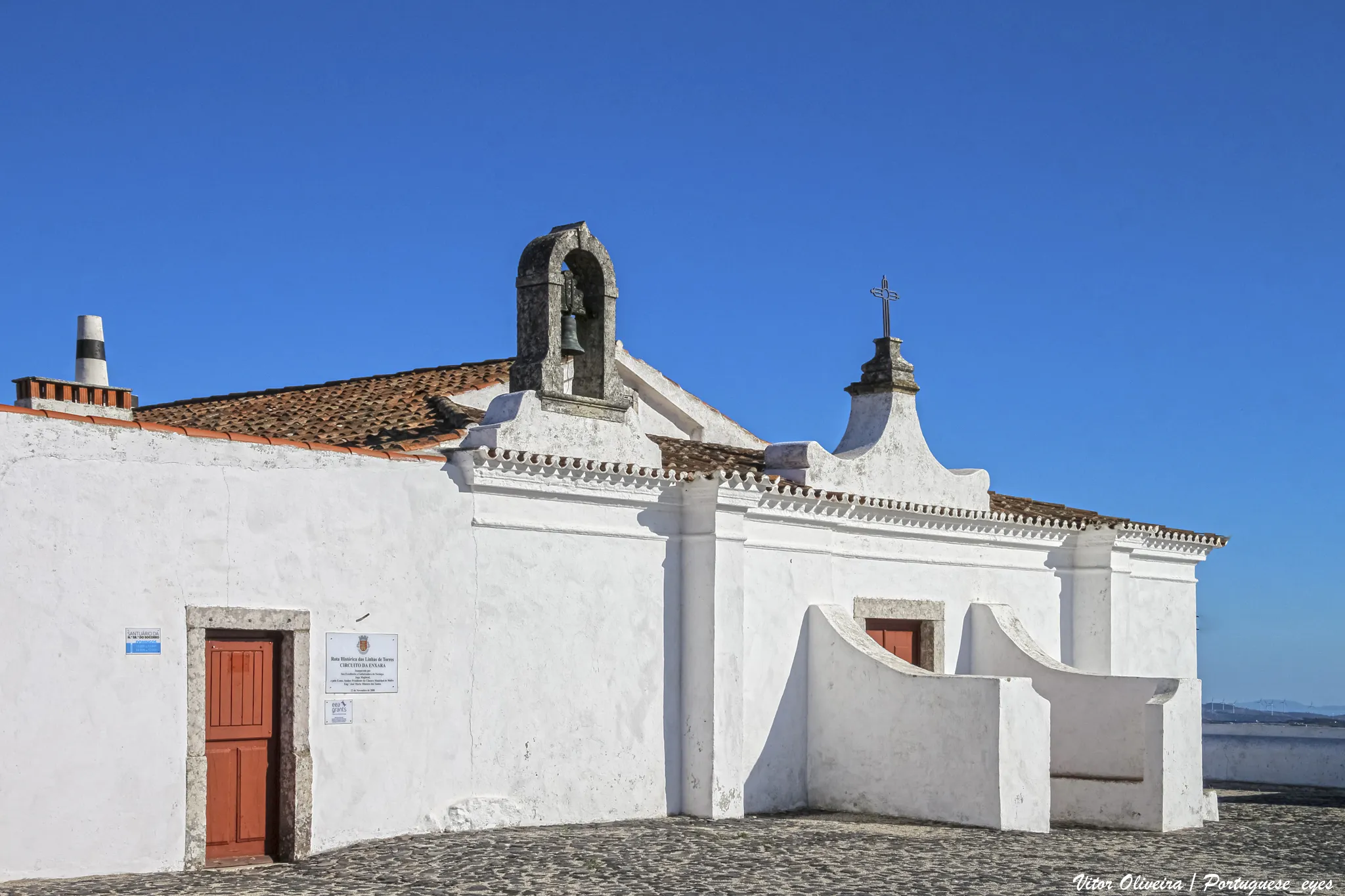 Photo showing: No cimo da serra do Socorro, a ermida de Nossa Senhora do Socorro, do séc. XVI, situa-se nos limites da freguesia do Turcifal e do concelho de Torres Vedras, no início do concelho de Mafra, freguesia de Enxara do Bispo, dentro de um povoado fortificado da idade do ferro. Segundo a tradição popular, durante a ocupação árabe terá sido uma mesquita, depois convertida ao cristianismo por D. Afonso Henriques. Nos séc. XVI e XVII teve obras que lhe deram o aspeto atual com características manuelinas. No altar-mor, sobre o sacrário, pode-se ver a imagem de Nossa Senhora do Socorro, com o menino, ladeada pelos seus pais S. Joaquim e S. Ana. É objeto de romaria, cujas festividades se realizam a 5 de agosto com realização de missa, procissão e arraial. natural.pt/protected-areas/paisagem-protegida-local-serra...