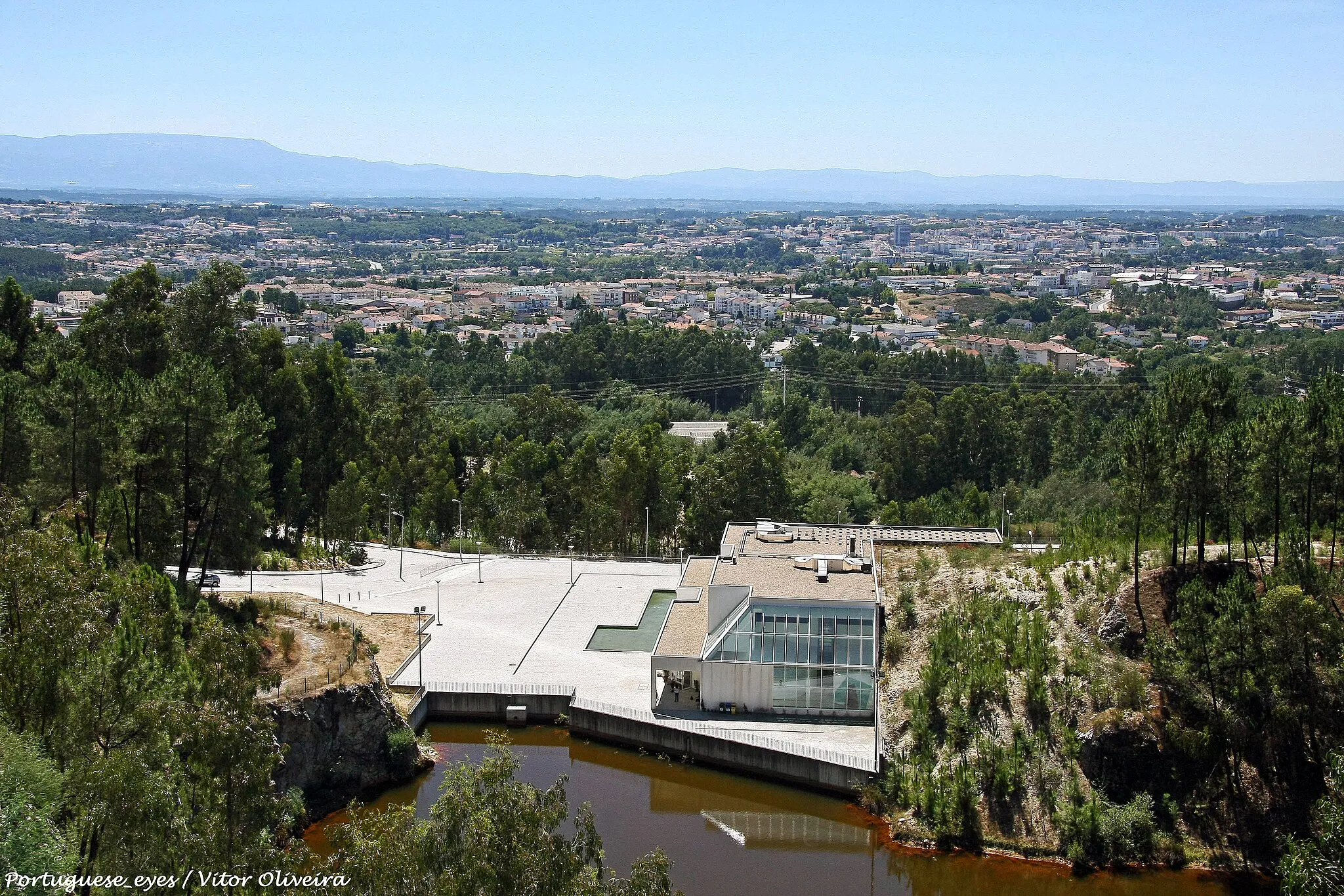 Photo showing: 1.Missão e objetivo:
O Museu do Quartzo pretende suscitar interesse pelo património geológico como parte integrante do património natural, promovendo a sua proteção, preservação e valorização. Visa dar a conhecer a geologia regional e o quartzo no contexto geológico e mineralógico e constituir-se como mais-valia pedagógico-didática para os vários níveis de escolaridade.
O projeto em que se enquadra o Museu do Quartzo visou a requalificação do Monte de Santa Luzia, que durante alguns anos, foi alvo de exploração desse mineral. O aproveitamento deste recurso deixou uma cratera, como que uma janela aberta na crosta terrestre que vale a pena observar.
Por solicitação da Câmara Municipal de Viseu, o Museu Nacional de História Natural, da Universidade de Lisboa, concebeu um projeto de valorização do sítio, envolvendo a sua aceitação como um geomonumento.
1.1. História e Edifício
Breve apresentação - O Museu foi concebido com dois pisos, disponibiliza uma área total de 1240 metros quadrados. O edifício, conta com um piso inferior, onde se
destaca a exposição permanente dedicada ao quartzo, com uma forte componente interativa onde o mineral é explorado em toda a sua importância mineralógica, geológica e económica. O primeiro piso disponibiliza também um auditório, uma sala de estudo e uma biblioteca.
O piso superior do edifício conta com uma área para exposições temporárias, uma área adaptada para experimentação pedagógica e um espaço para os mais pequenos - Rochas, Rochinhas, Minerais e Miúdos.
Exposição permanente      
A exposição permanente do Museu do Quartzo distribui-se em 6 núcleos:

Núcleo 1: Santa Luzia: O Monte e o Filão
Núcleo 2: A Terra: Fonte de Quartzo
Núcleo 3: Minerais: O Reino do Quartzo
Núcleo 4: Laboratório: As Propriedades dos Minerais
Núcleo 5: Cristais de Quartzo
Núcleo 6: Aplicações: O Quartzo no Tempo e na História Exposição "A Tua Casa – O Teu Reino Mineral"
A presença de rochas, minerais e elementos na nossa casa. Desde sempre os recursos minerais tiveram uma importância significativa na sociedade. Nenhuma civilização pode prescindir do uso dos bens minerais uma vez que muitas das necessidades básicas do ser humano dependem largamente destes recursos.
Pretende-se demonstrar a enorme importância dos recursos minerais no nosso quotidiano, pelas inúmeras aplicações em objetos do dia-a-dia.
Experimentação pedagógica

Aqui as crianças poderão realizar as mais variadas experiências relacionadas com a geologia, a mineralogia e as ciências da Terra em geral, poderão observar à lupa binocular algumas rochas e minerais. Têm também disponíveis jogos de computador sobre rochas, minerais e geologia em geral.